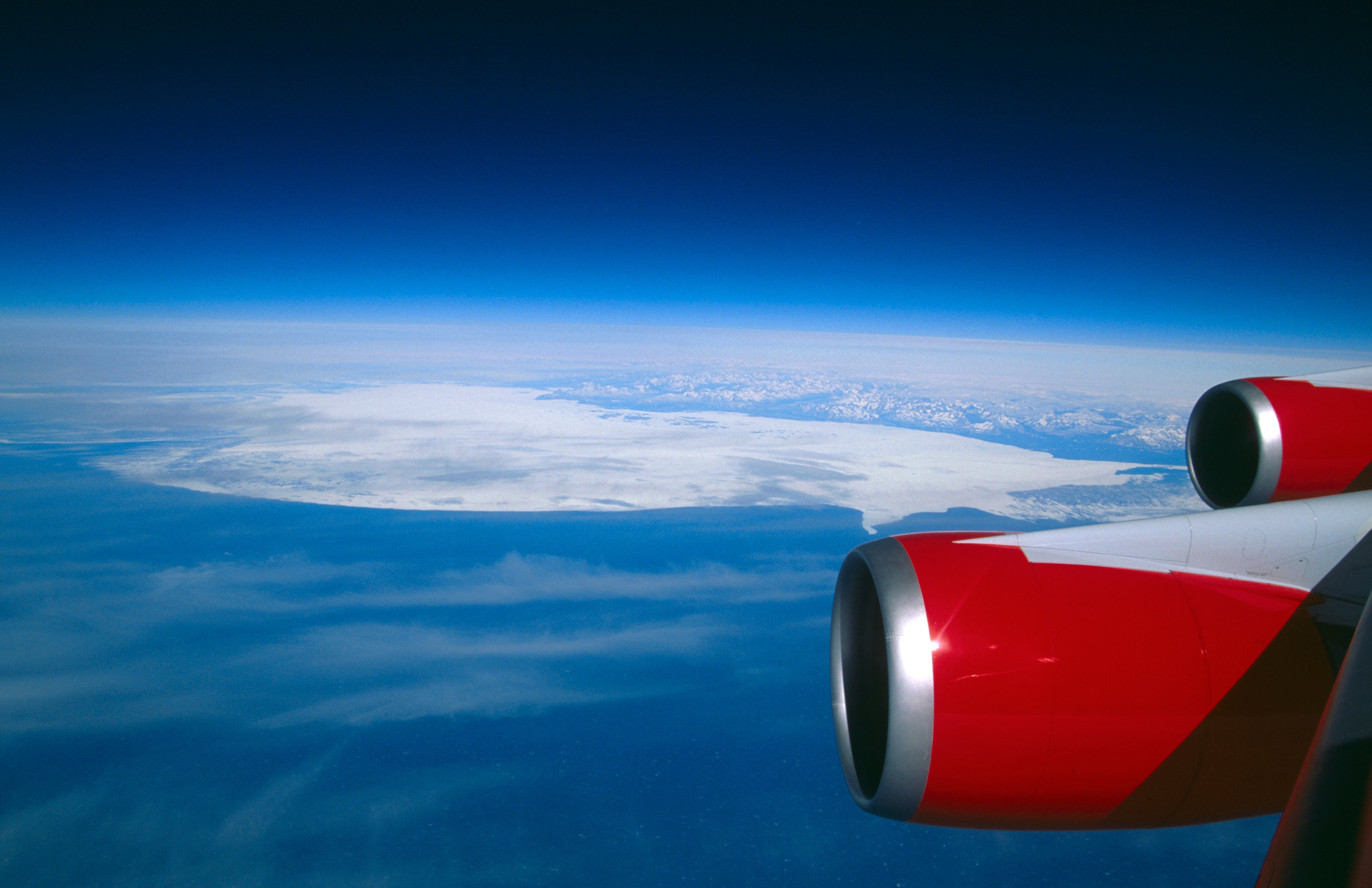 GE CF6-80C2 engine cowlings of a Virgin Atlantic Airways Boeing 747-400 flight from LHR-LAX over the North Atlantic Ocean showing the curvature of the earth with an iceberg covered in snow