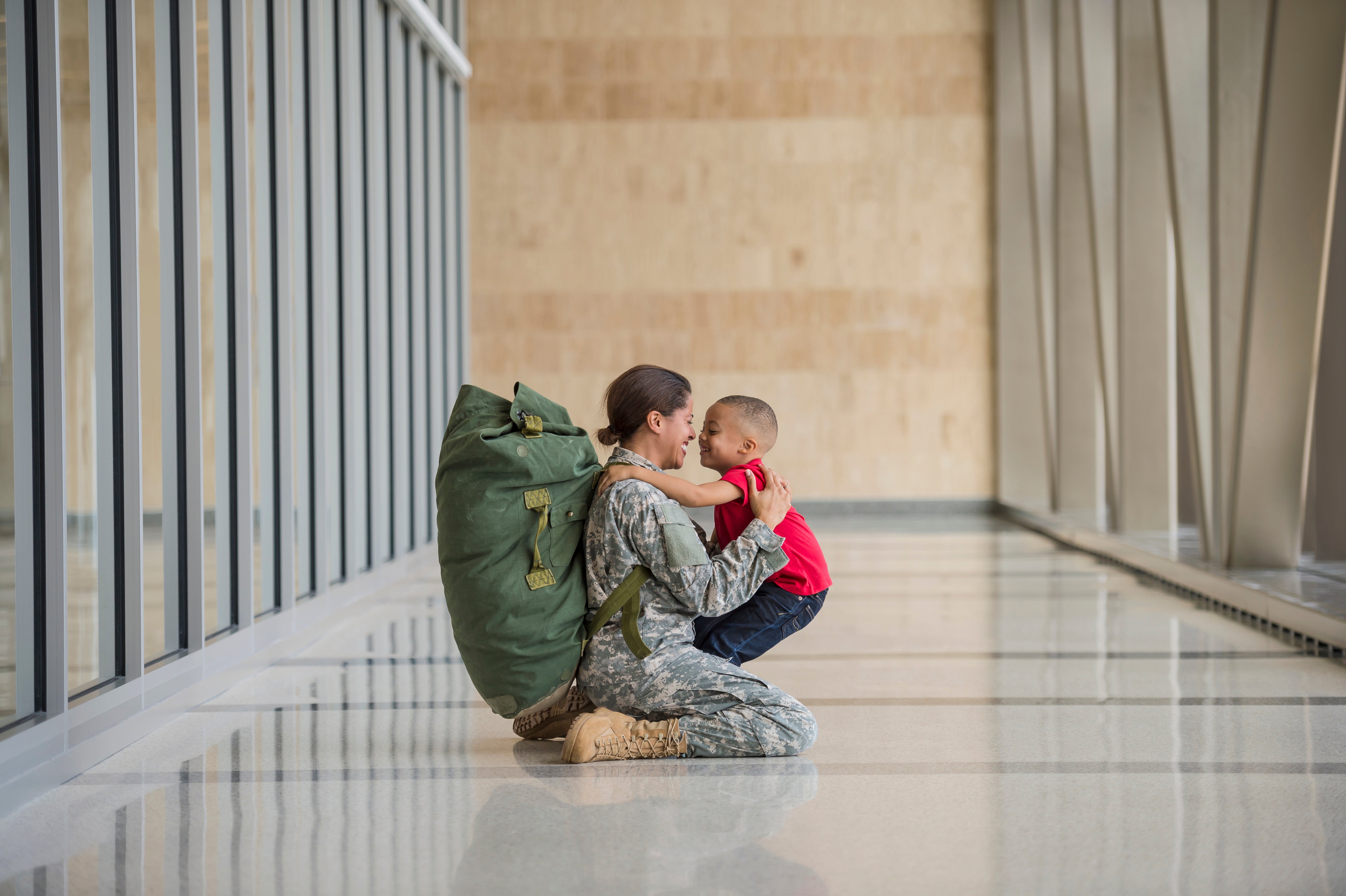 African American soldier hugging son in airport