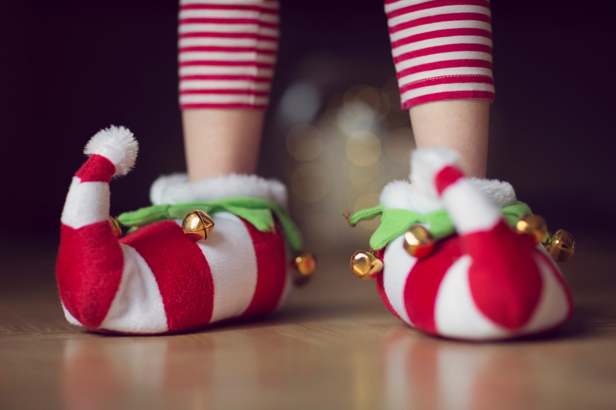Child wearing Christmas elf novelty slippers with bells