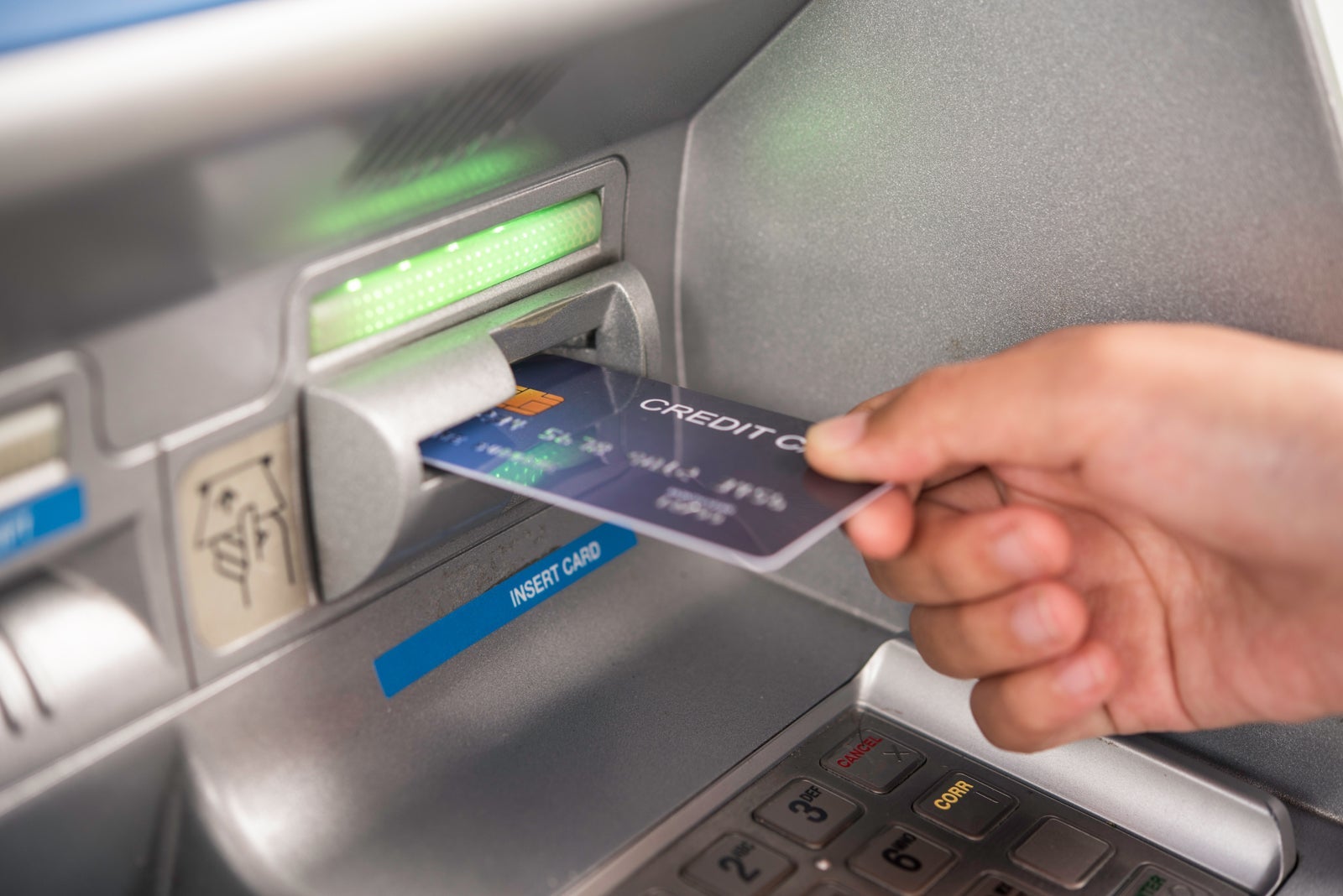 Cropped Hand Inserting Credit Card In Atm Machine