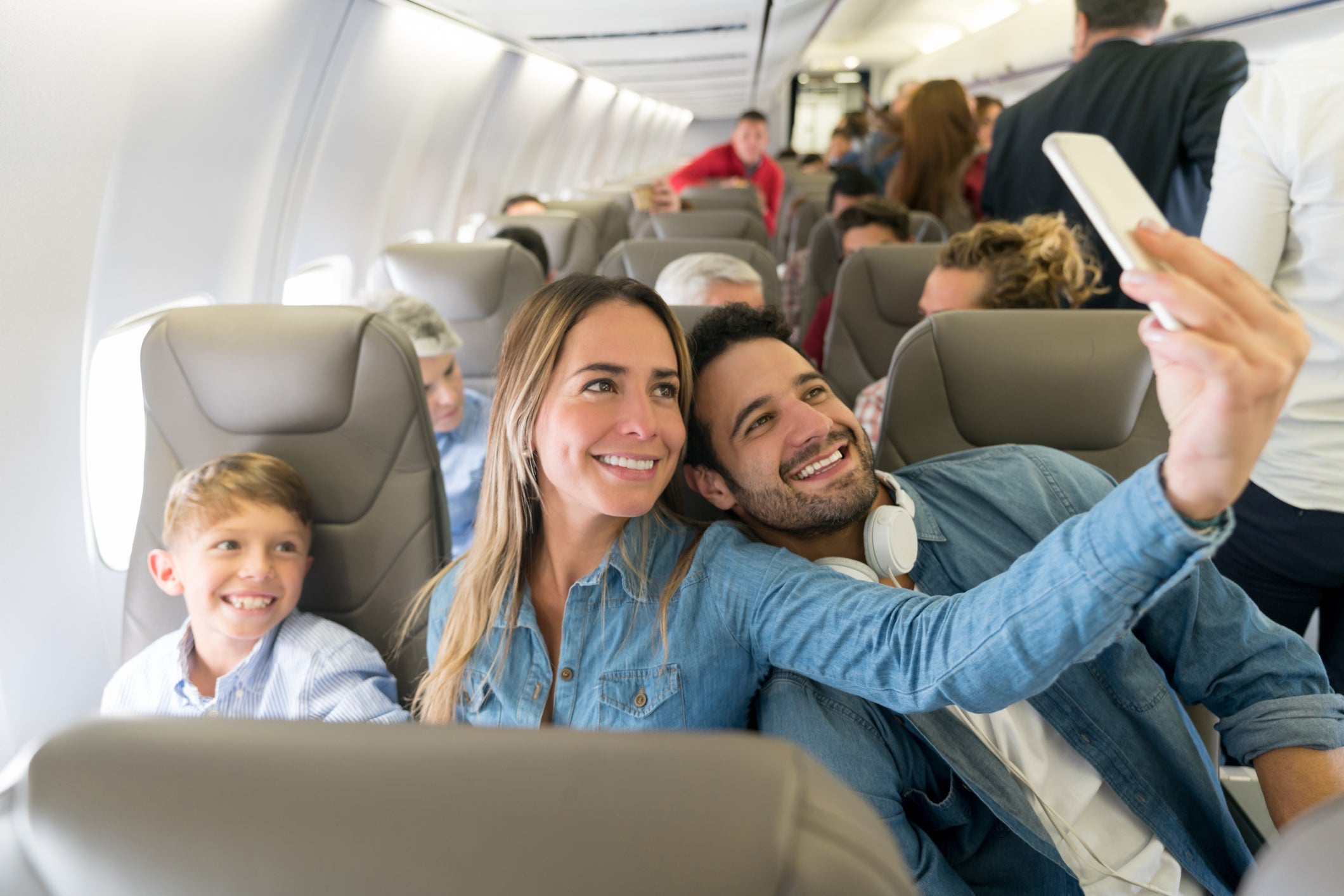 Happy family traveling by plane and taking a selfie