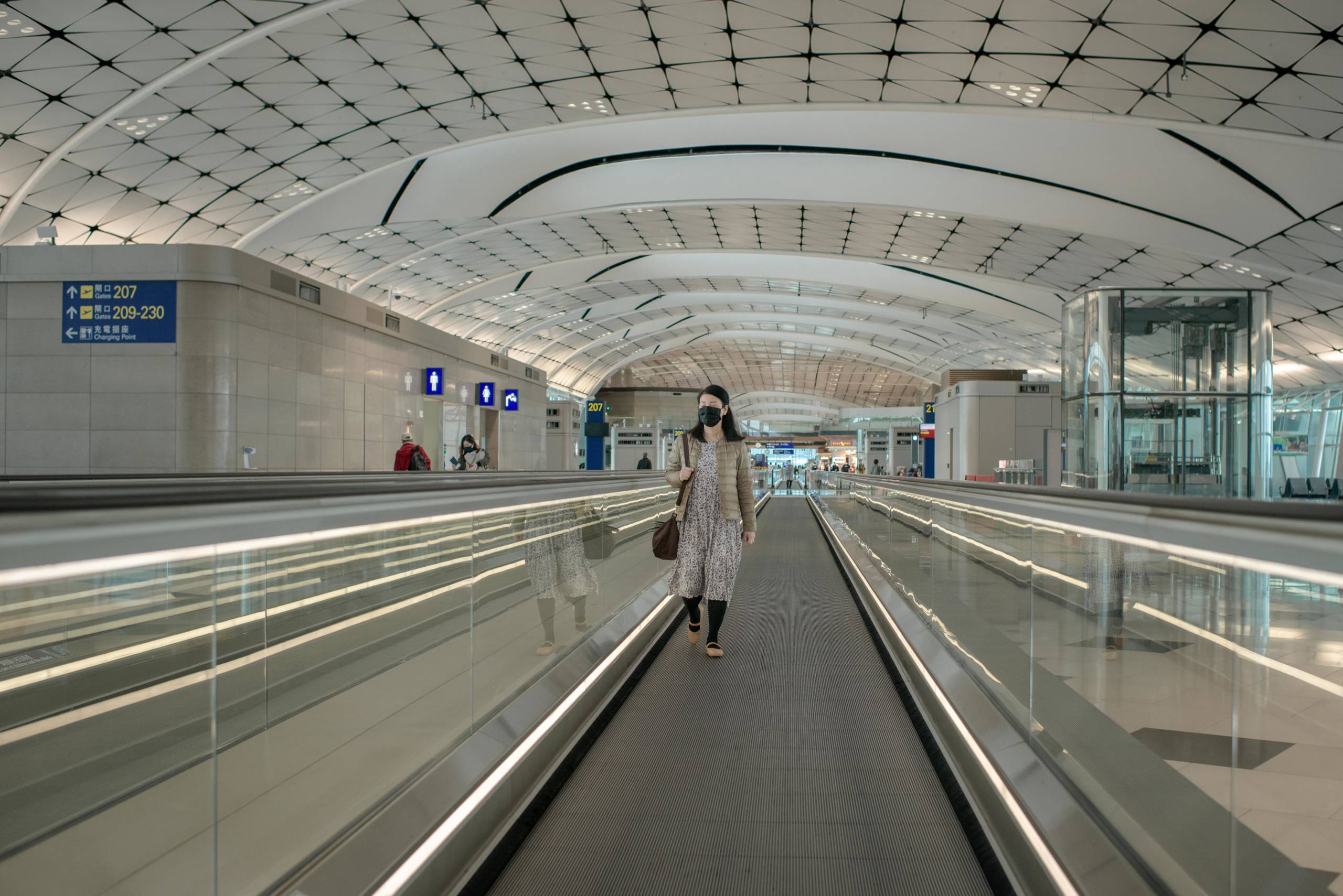 A passenger wears a surgical mask at an empty departure