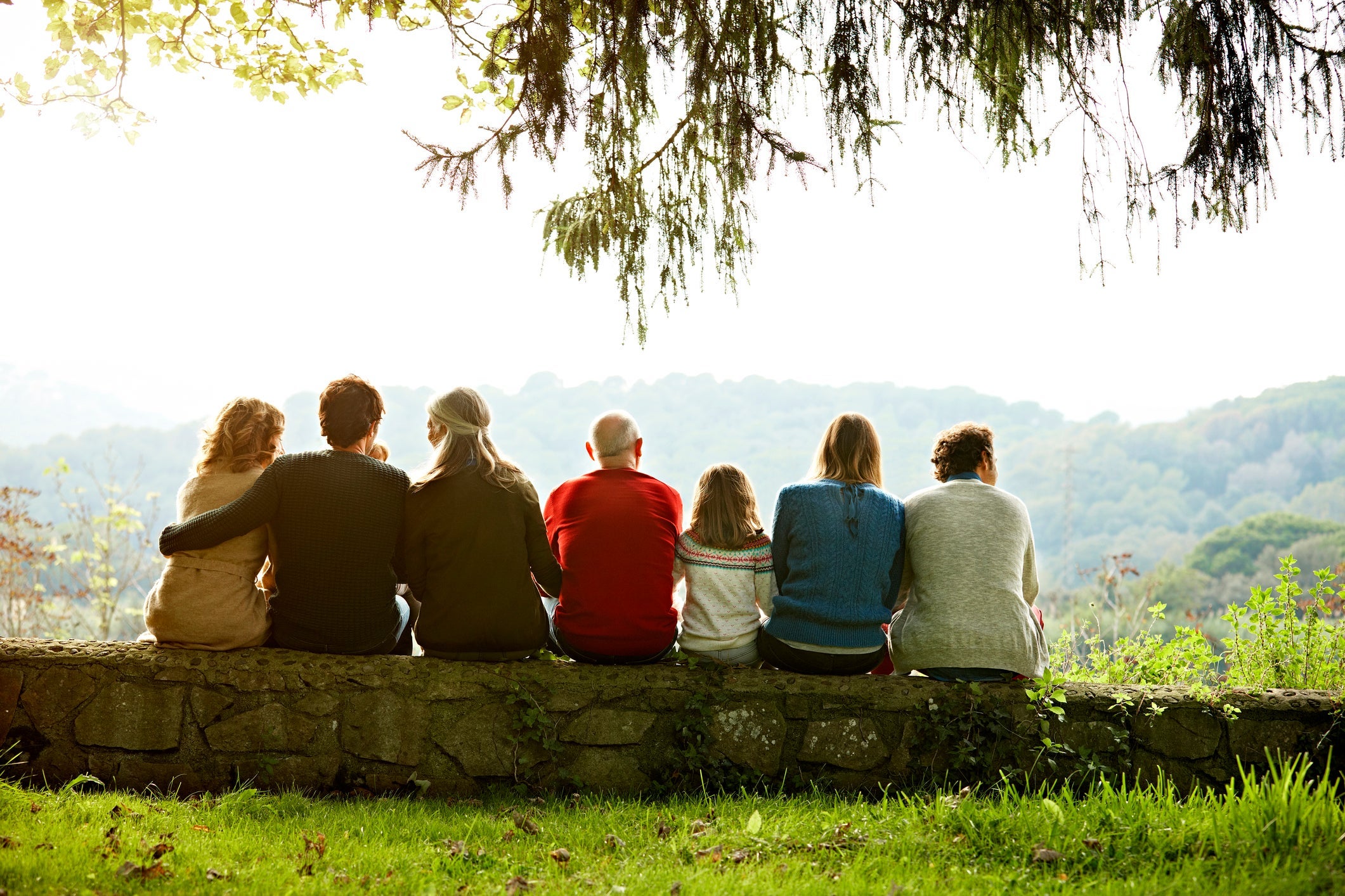 Multi-generation family relaxing on retaining wall