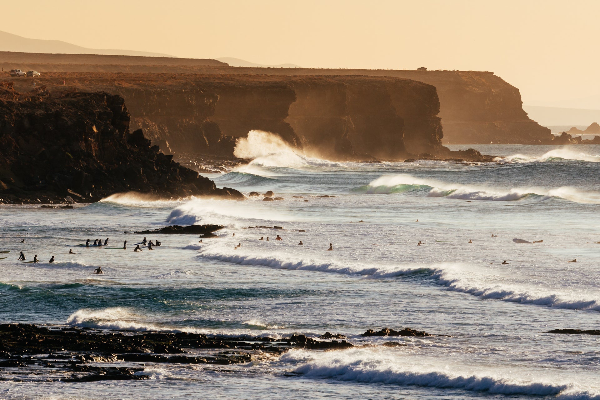 El Cotillo cliffs and beaches with waves and surfers at sunset, Fuerteventura