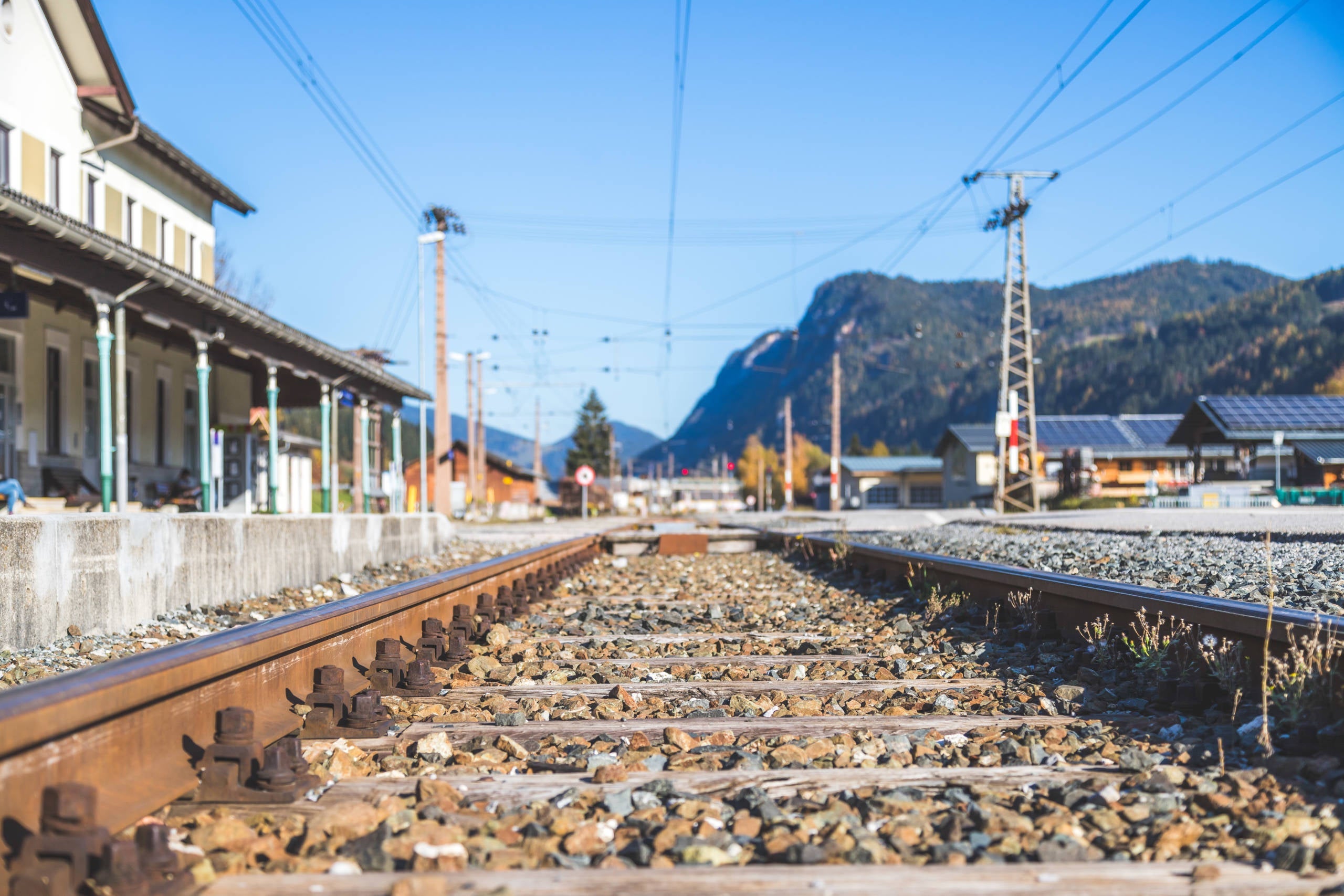 Sustainable traveling by train: Rail track and colorful, idyllic landscape in fall.