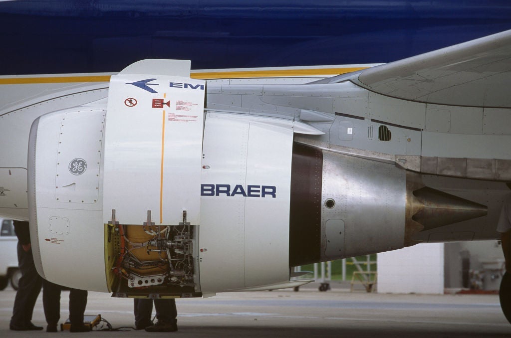 Engineers inspecting inside the open engine cowling