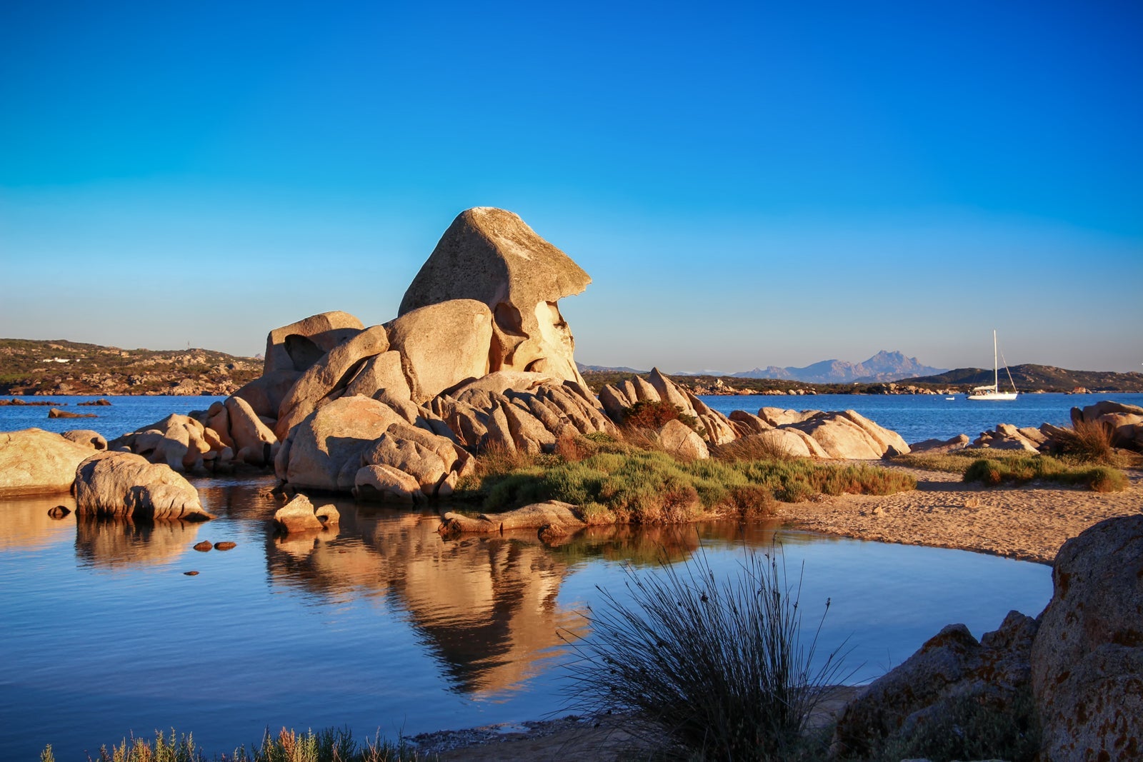 Rock Formations By Sea Against Clear Blue Sky