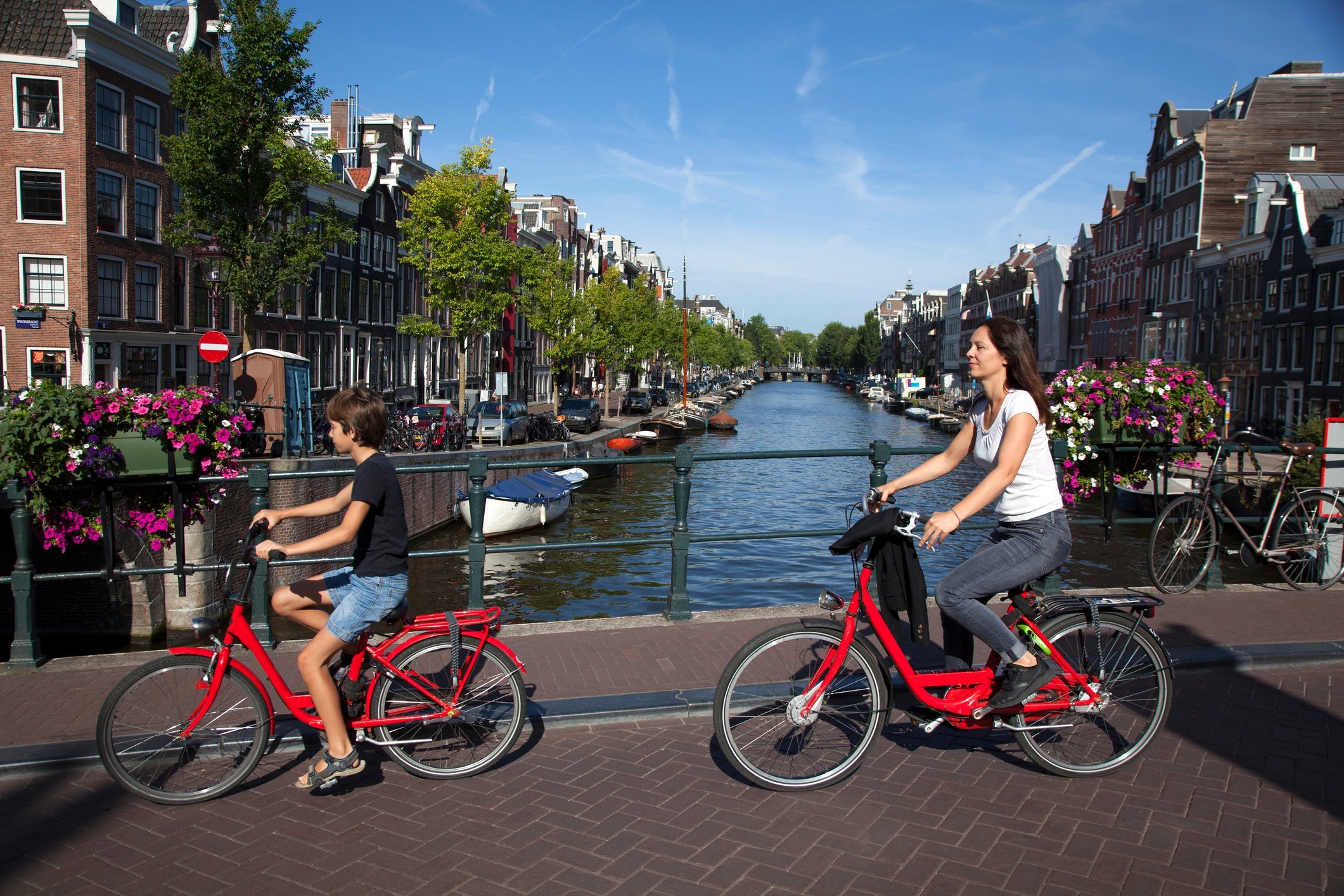 Cyclist crossing a canal bridge, child and woman