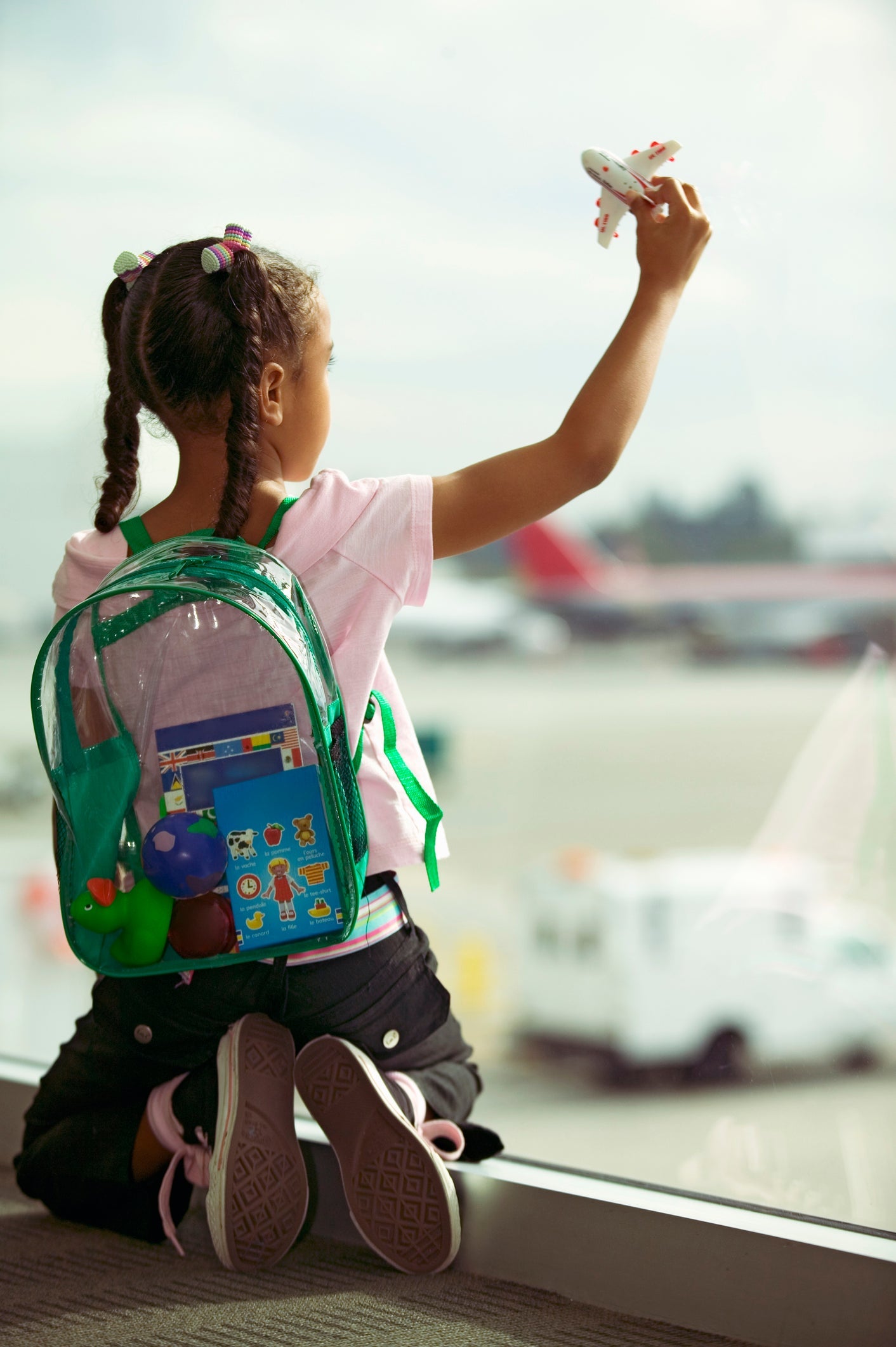 Young girl playing with toy airplane