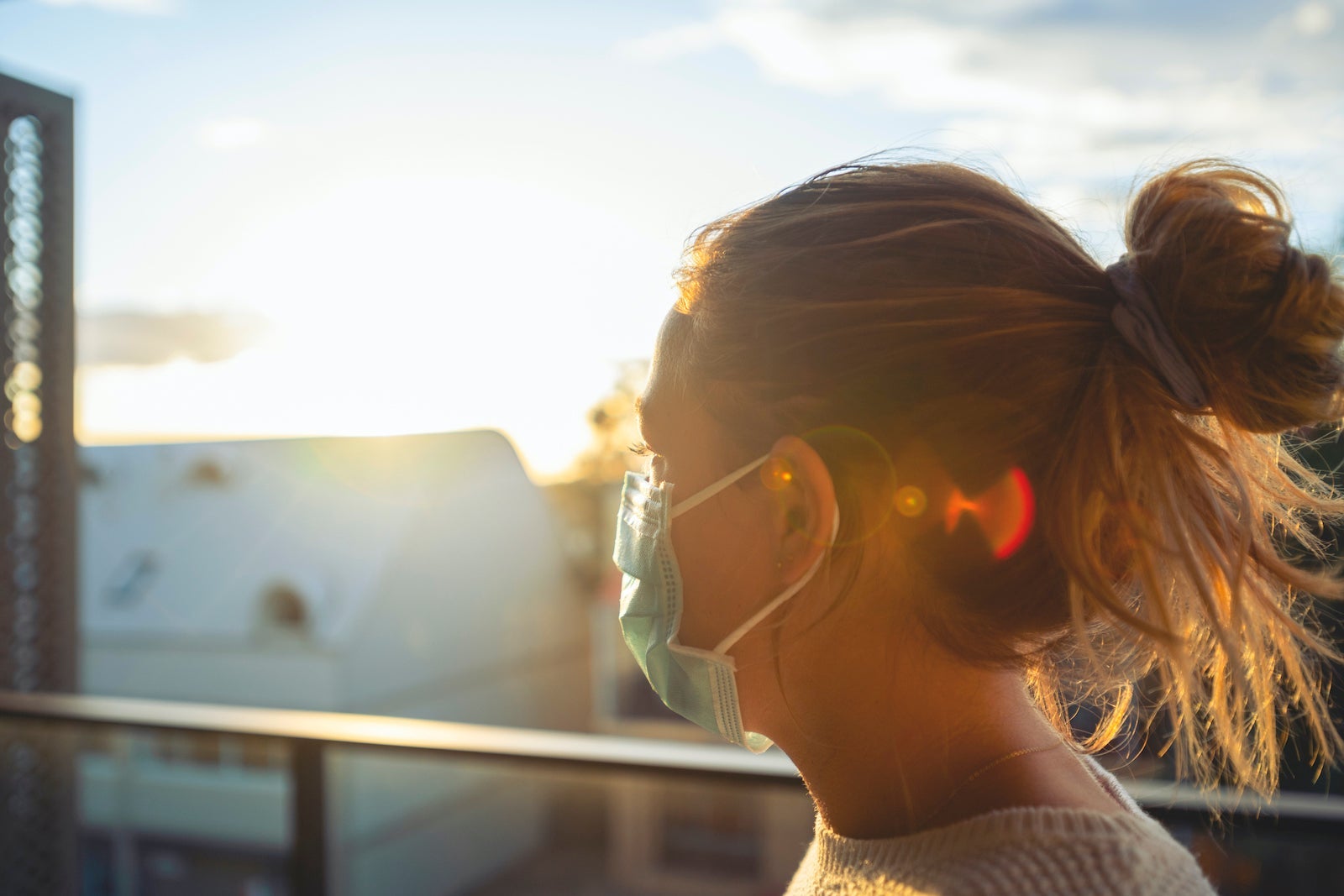 Woman looking from her balcony at sunset.