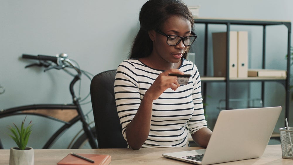 young woman at computer with credit card