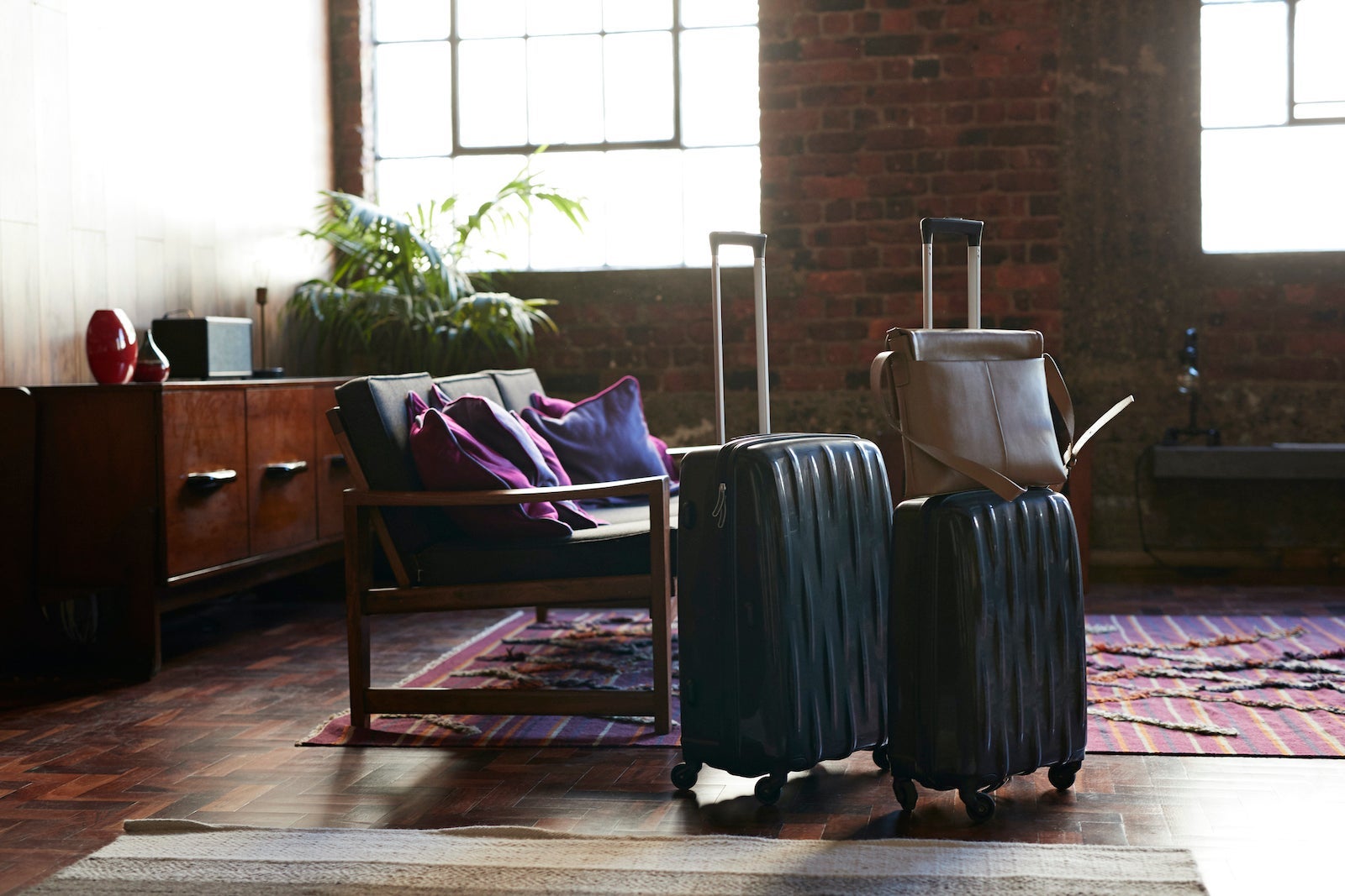 Still-life of suitcases and shoulder bag, on the floor of cool holiday apartment