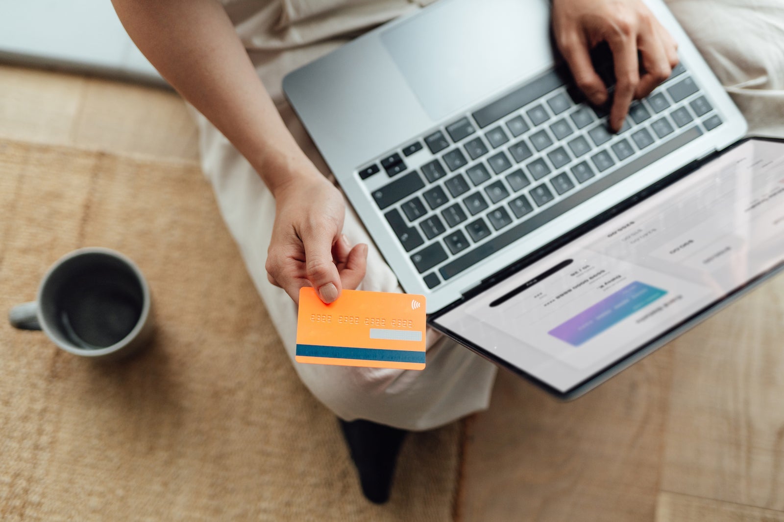 High angle view of young woman doing online shopping with laptop and making payment with credit card