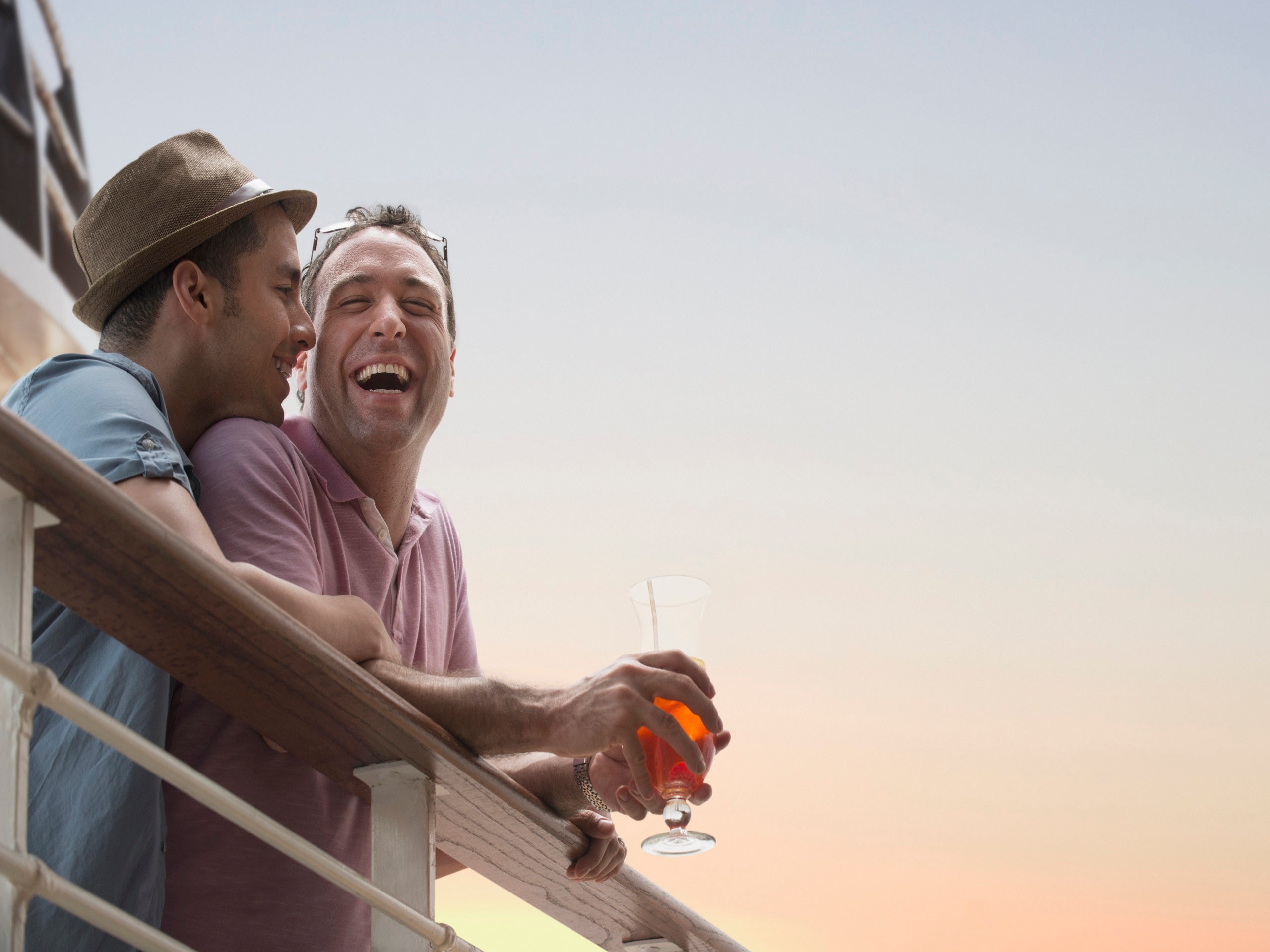 Gay couple having drinks on cruise ship deck