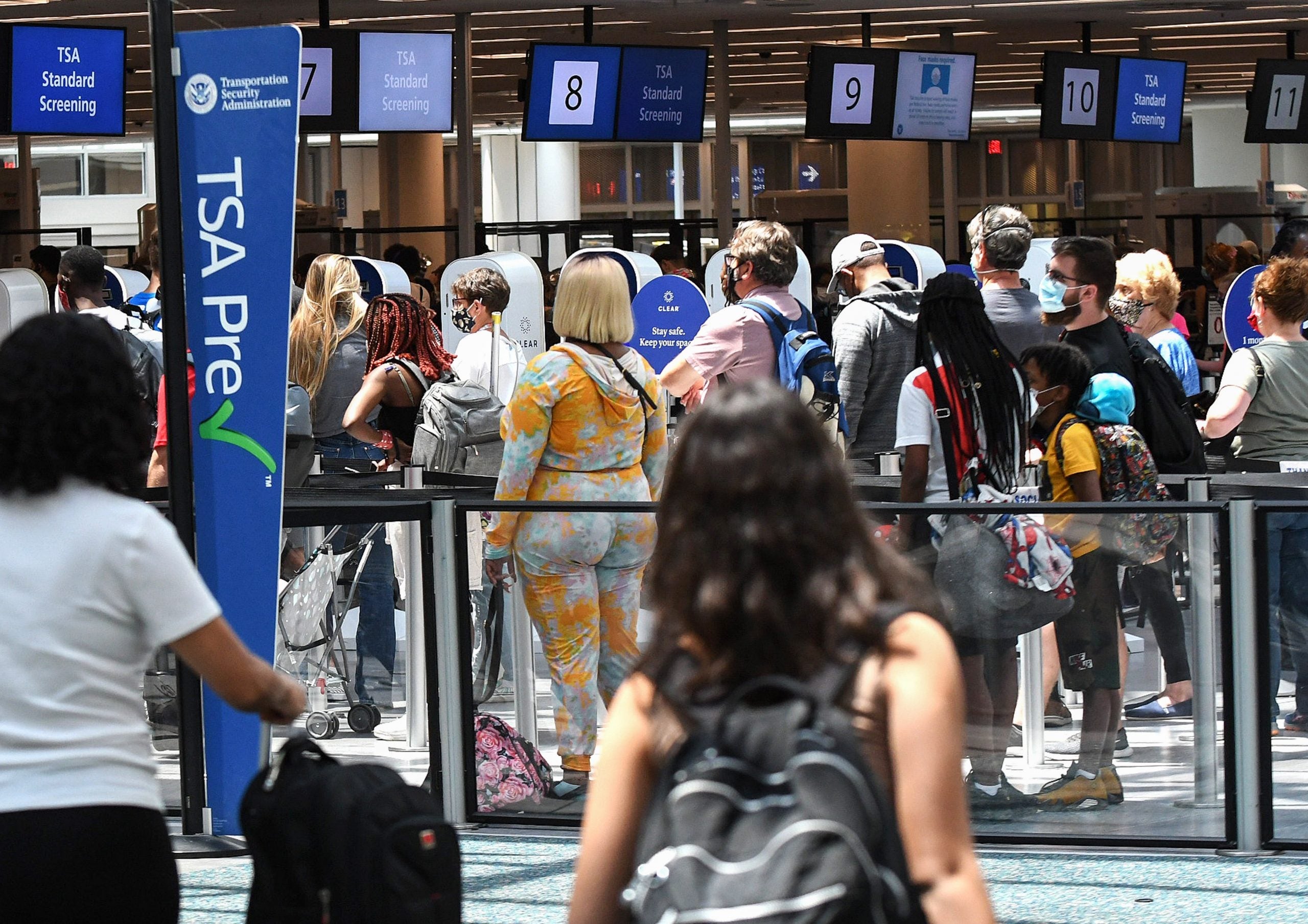 Travelers wait in line at a Transportation Security
