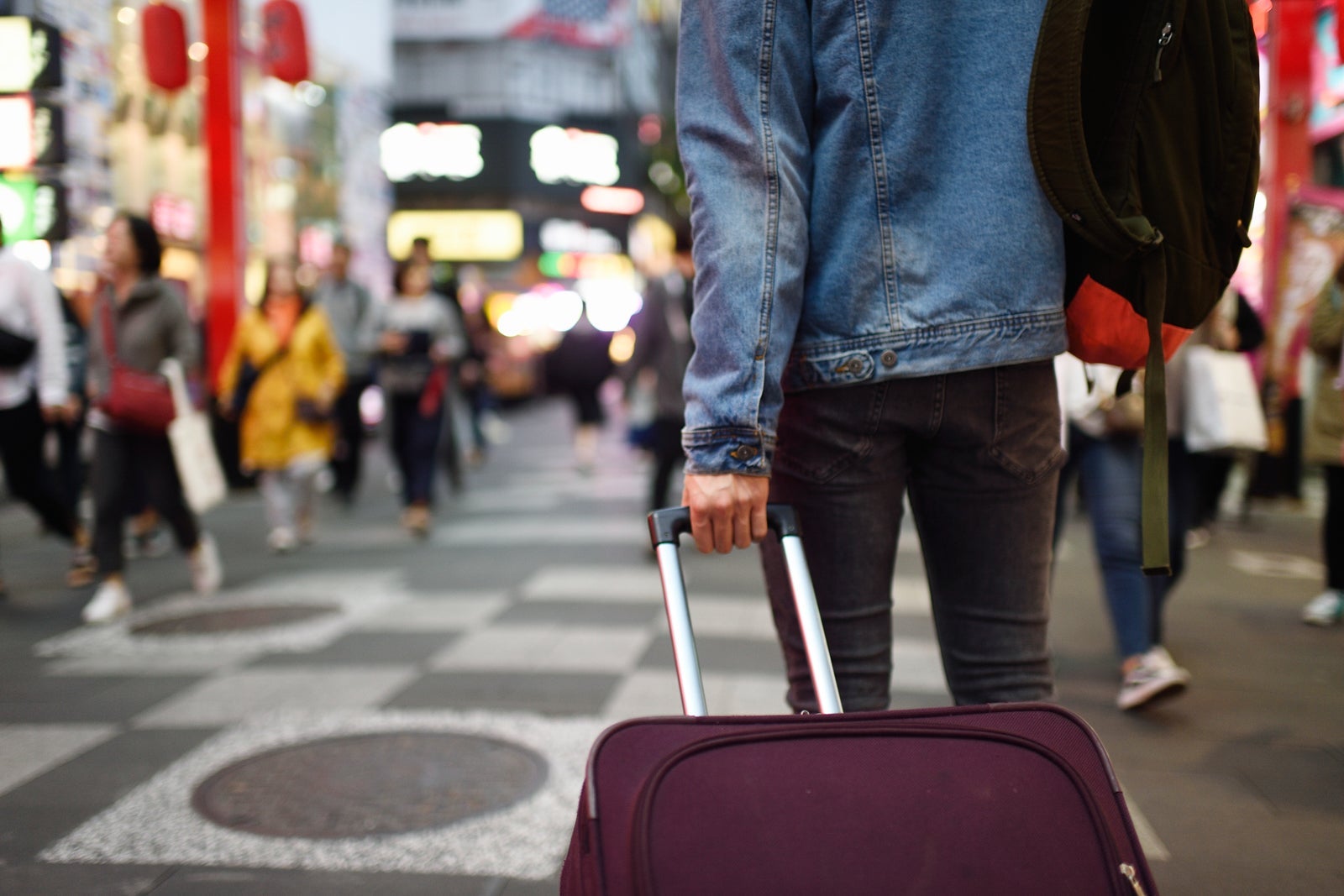 Man with suitcase in busy shopping district