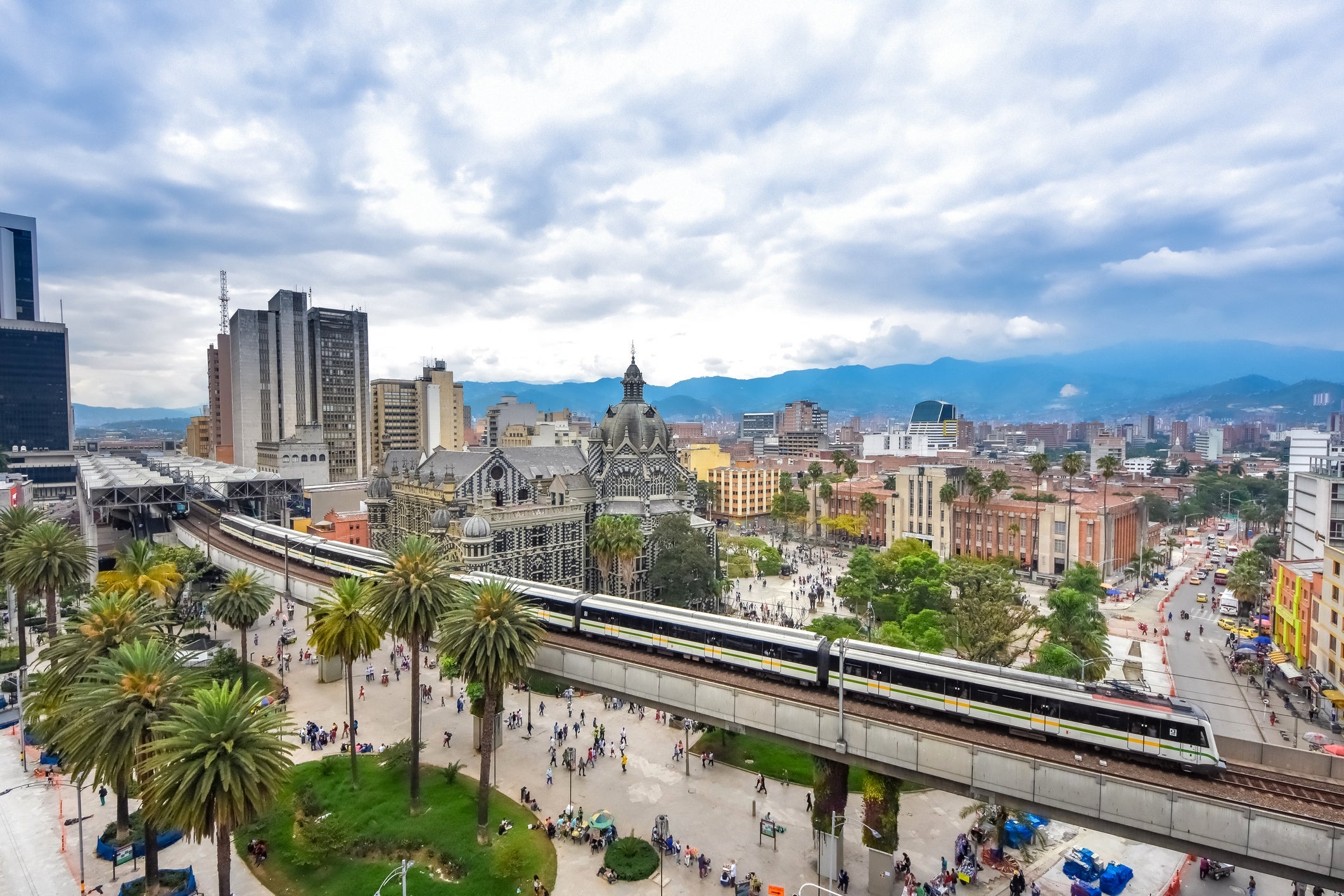 High angle view of Medellin cityscape with elevated metro train on foreground in Antioquia, Colombia