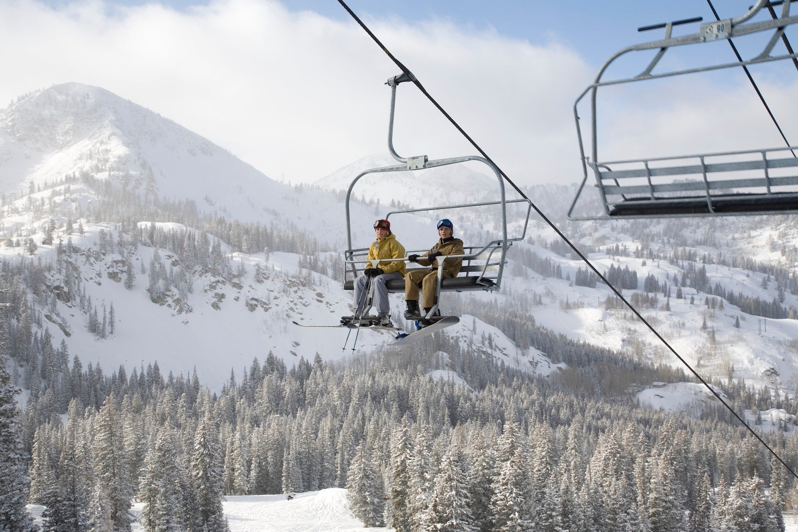 USA, Utah, teenage girl and boy (13-16) sitting on ski lift at Brighton ski resort