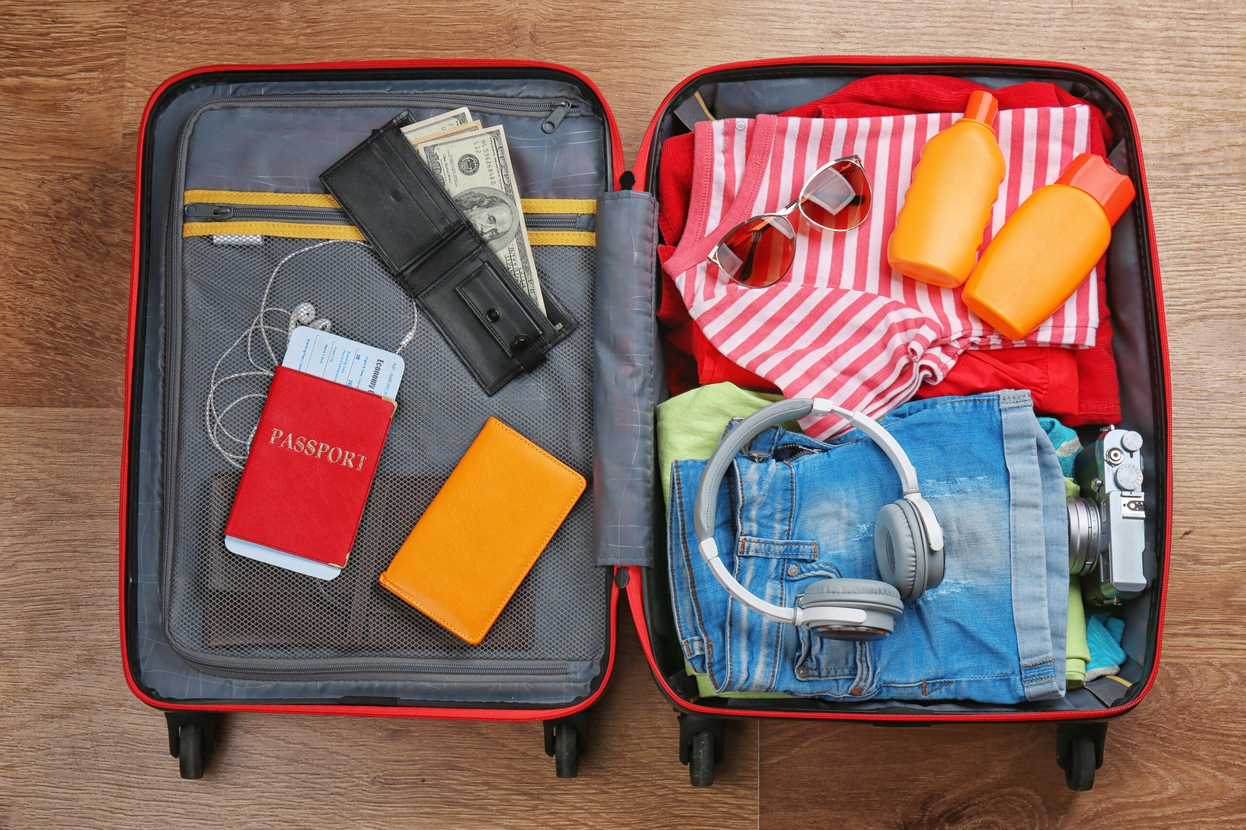 Open,Suitcase,With,Travel,Accessories,On,Wooden,Floor