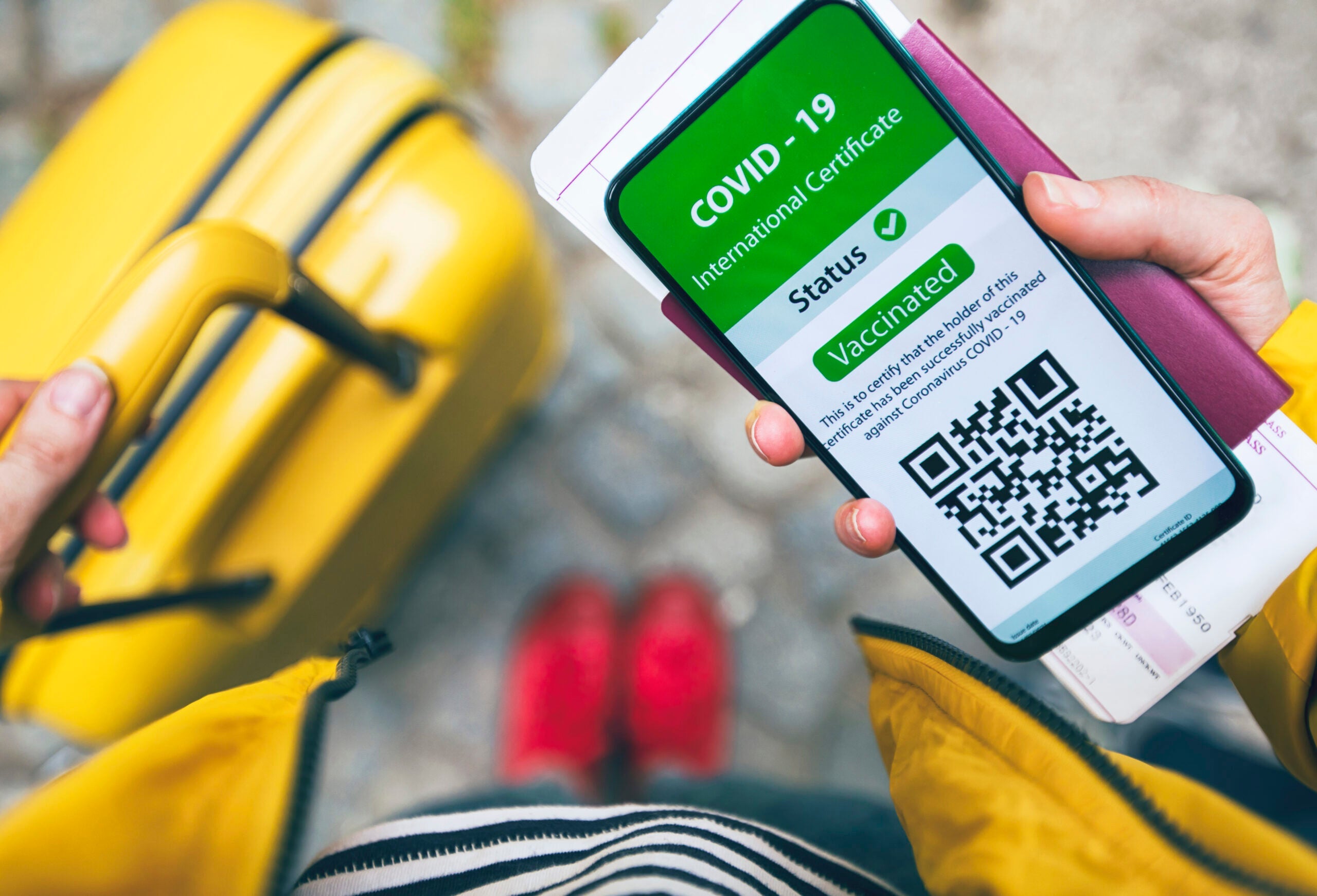 Woman using digital vaccine passport app оn mobile phone for traveling