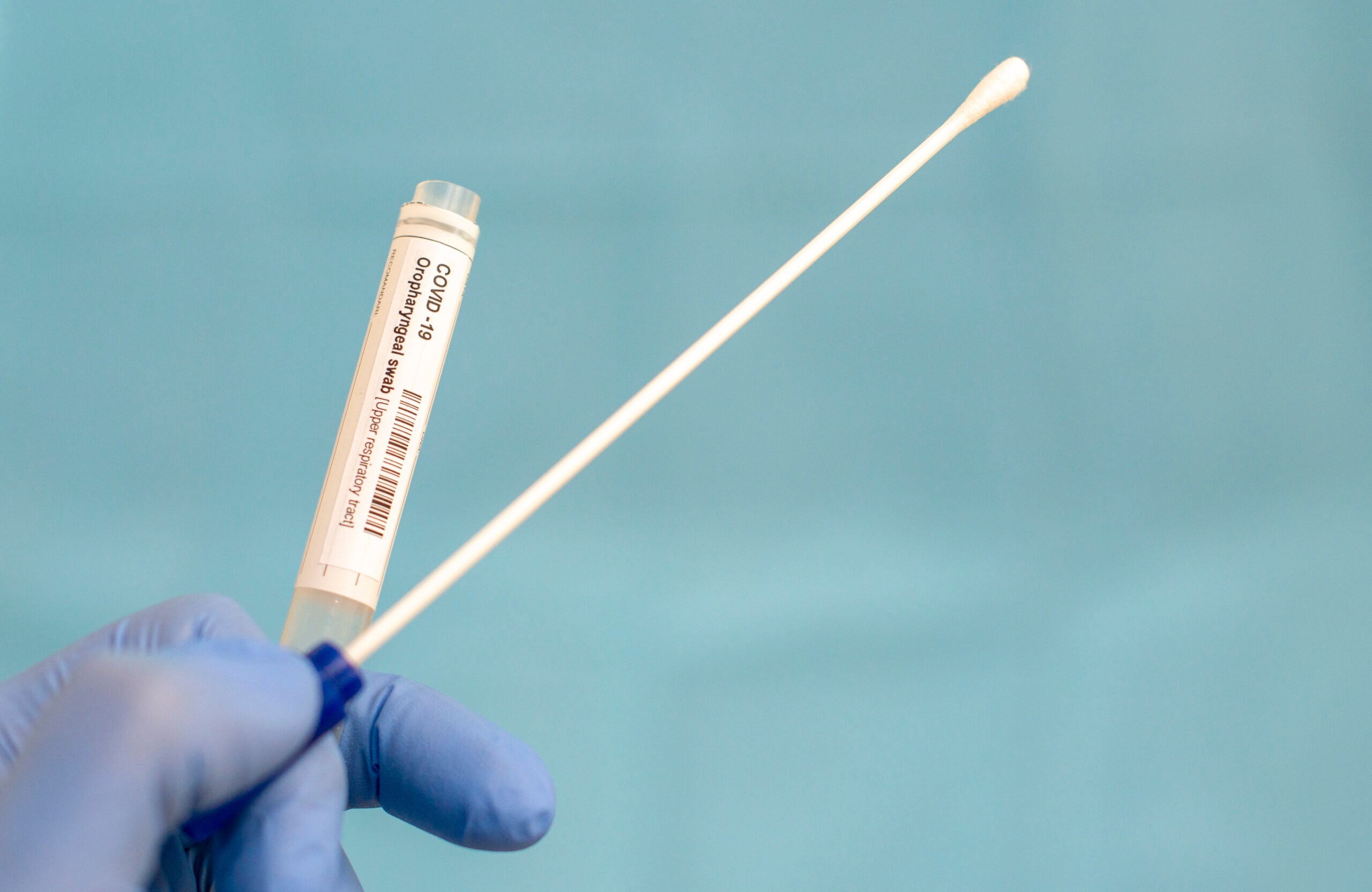 Cotton swab and test tube for Coronavirus test (COVID-19)), macro image of medical equipment in hands of healthcare professional