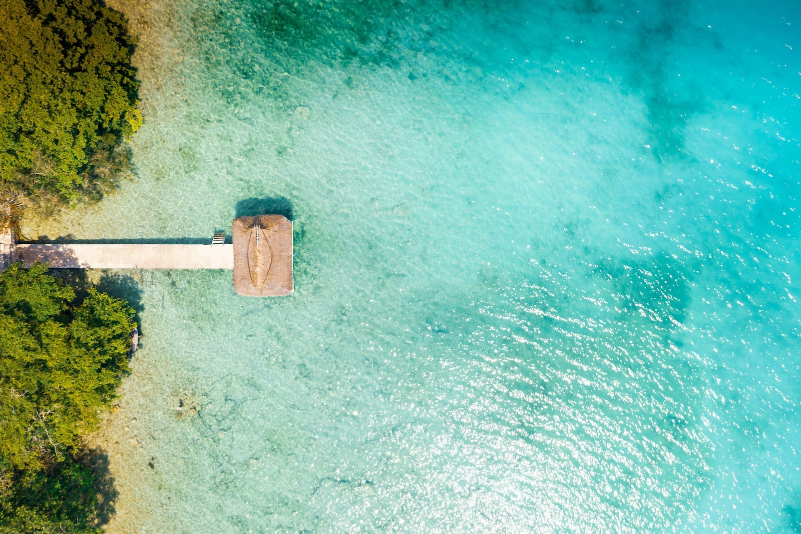 View of a wooden walking path at Bacalar, Mexico at sunrise