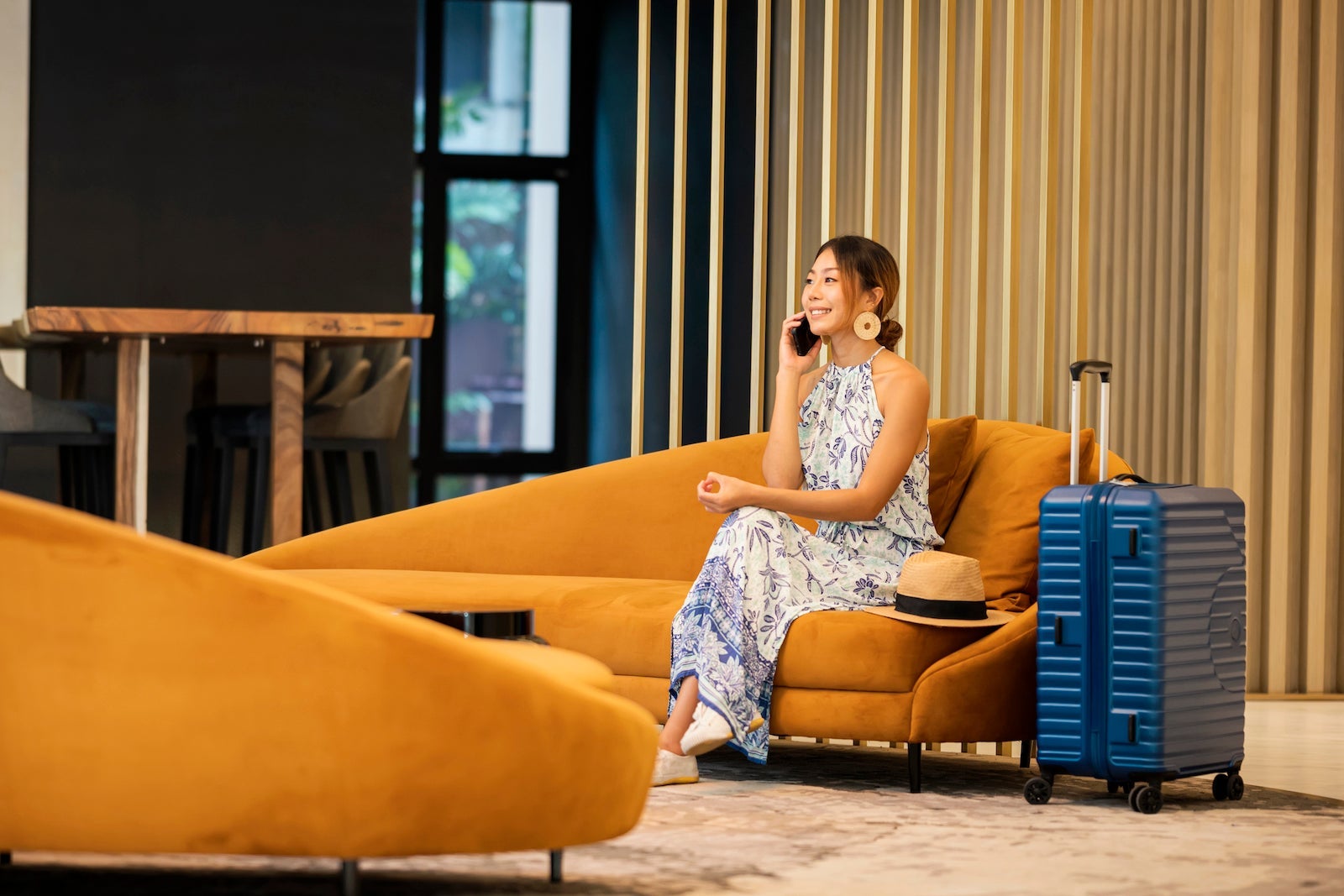 Young Tourist Women on phone call by sitting on sofa at hotel lounge , entrance hall.