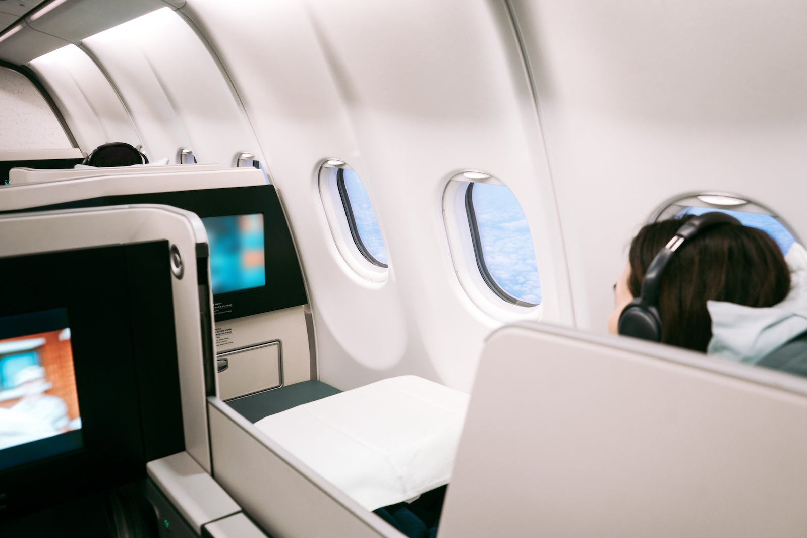Passenger using on board entertainment on business class of aircraft
