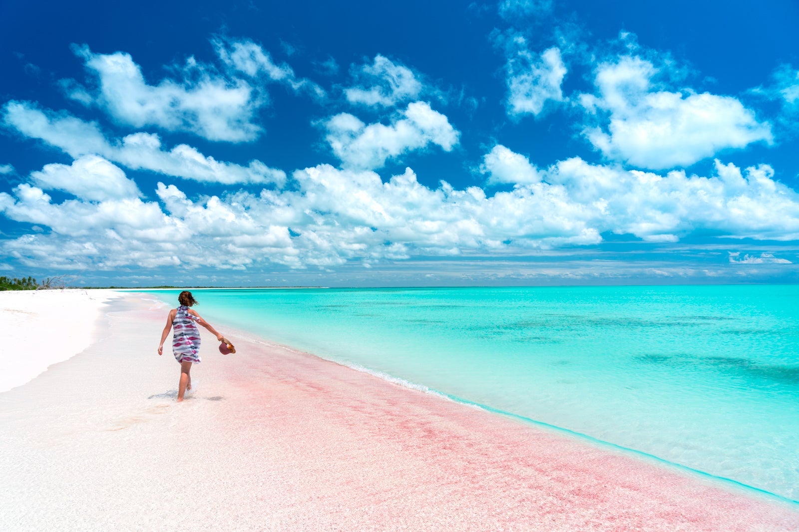 Woman walking through shallow crystal water, Caribbean