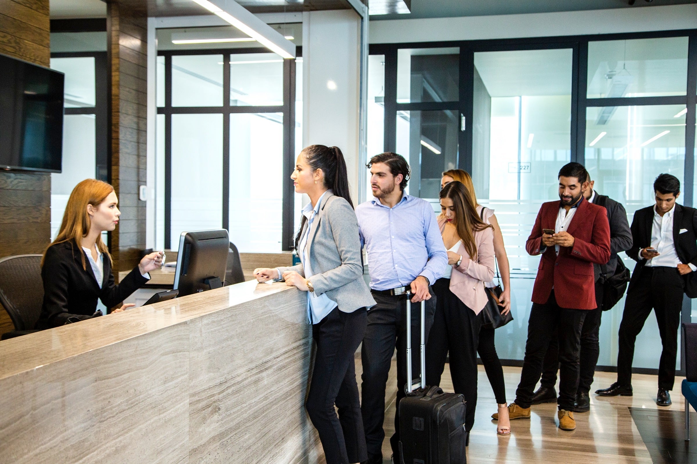 People in a line at a hotel check in desk