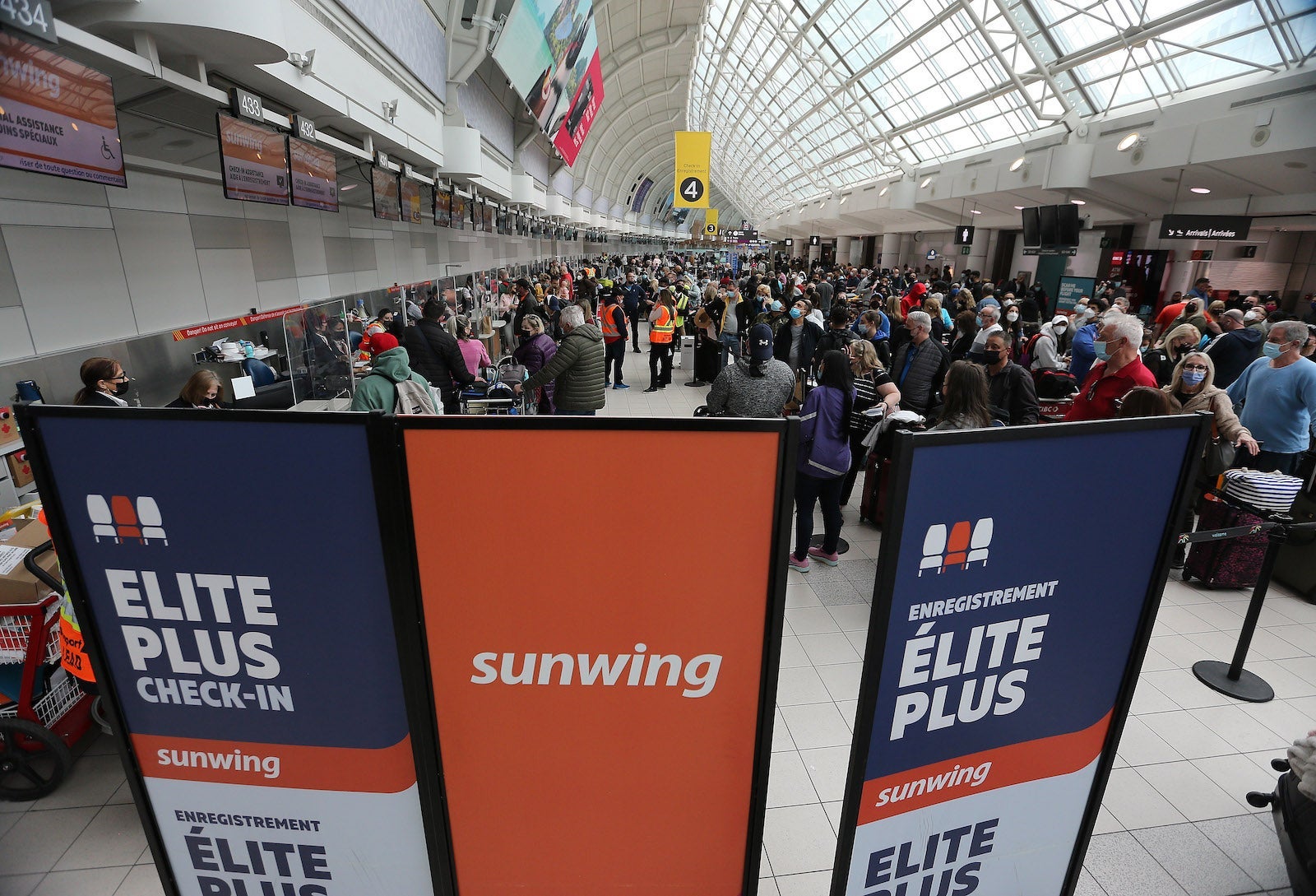 Passengers wait to be allowed onto their Sunwing flights after some have been delayed over a day