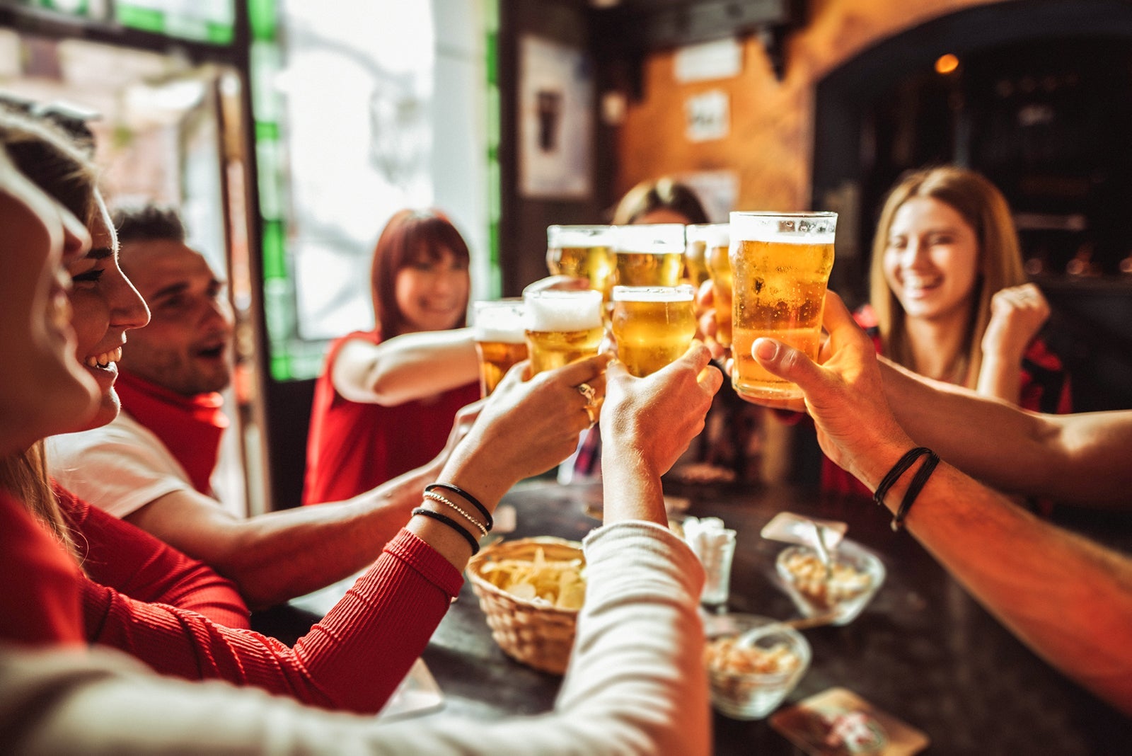 people talking and toasting in a pub with the beers