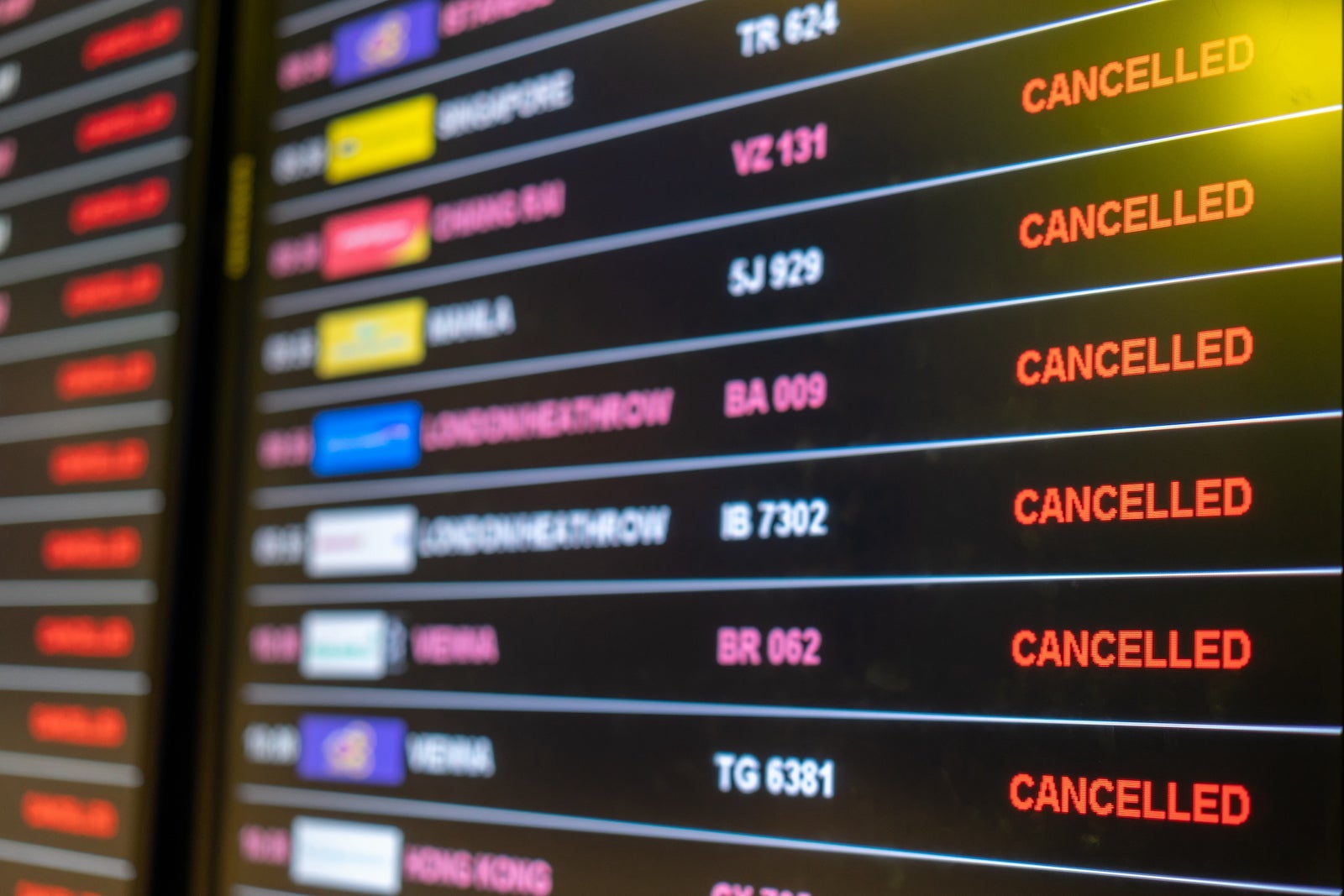 Airport departures board showing a number of flights boarding, or on their cancelled .