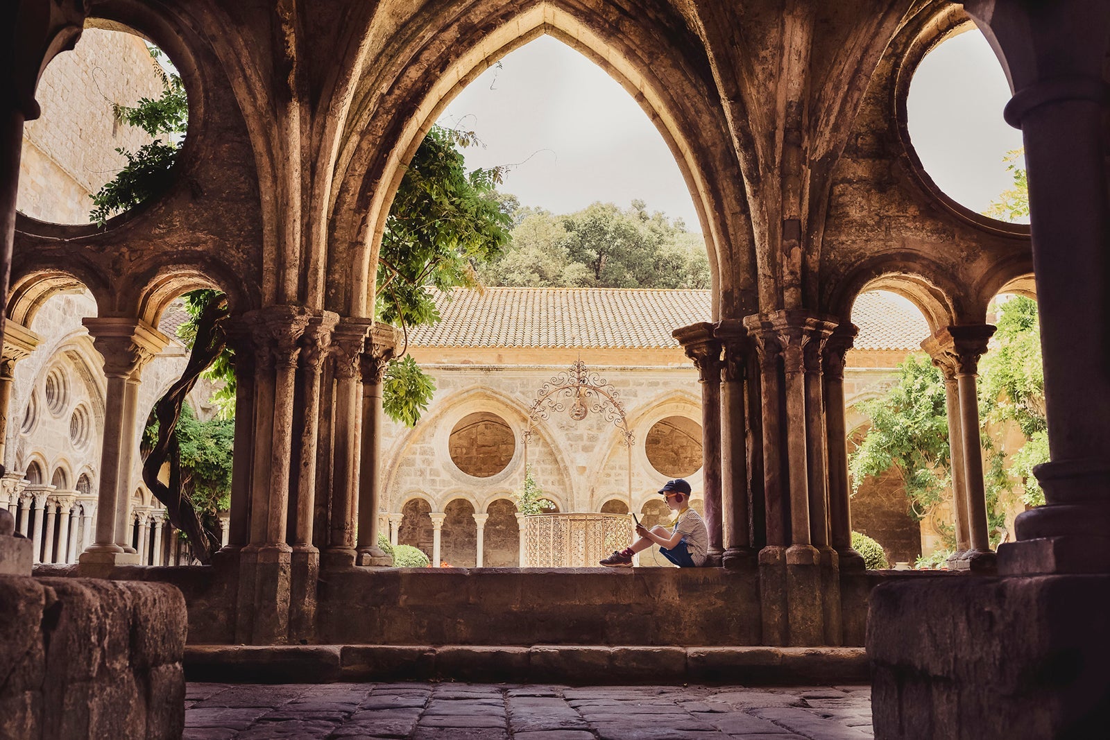France, Languedoc, Narbonne, Frontfroide Abbey, boy listening to the audio guide
