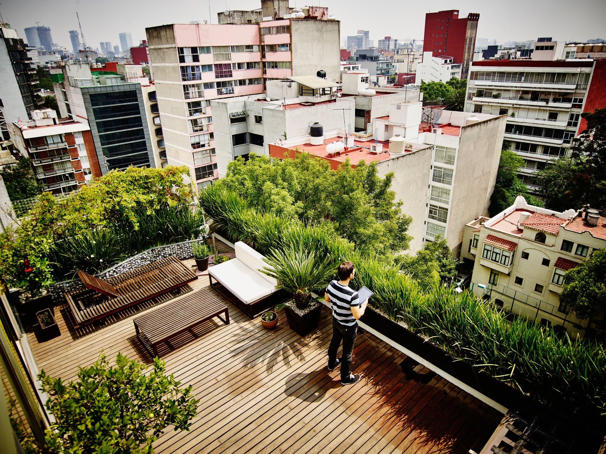Man with digital tablet on rooftop terrace of home