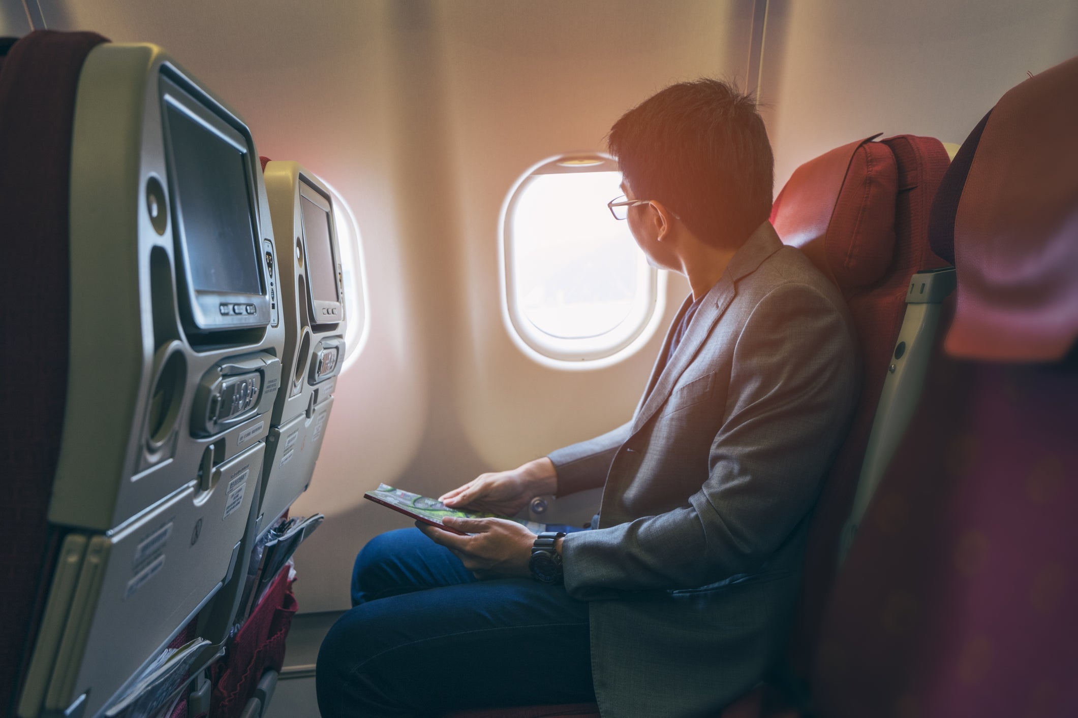 Person sitting at window seat of airplane stock