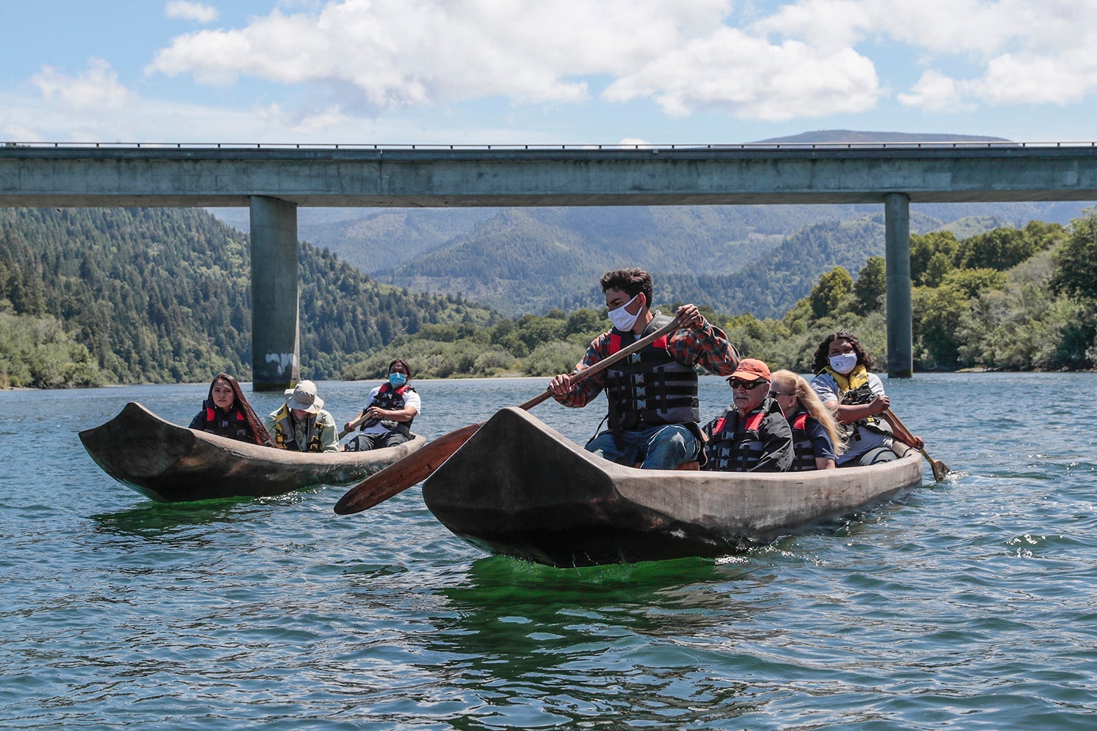 Yurok guides Zechariah Gabel, front, Sammy Gensaw, right and Jon-Luke Gensaw, left, paddle tourists along the Klamath River in traditional canoes hand crafted from Redwood trees.