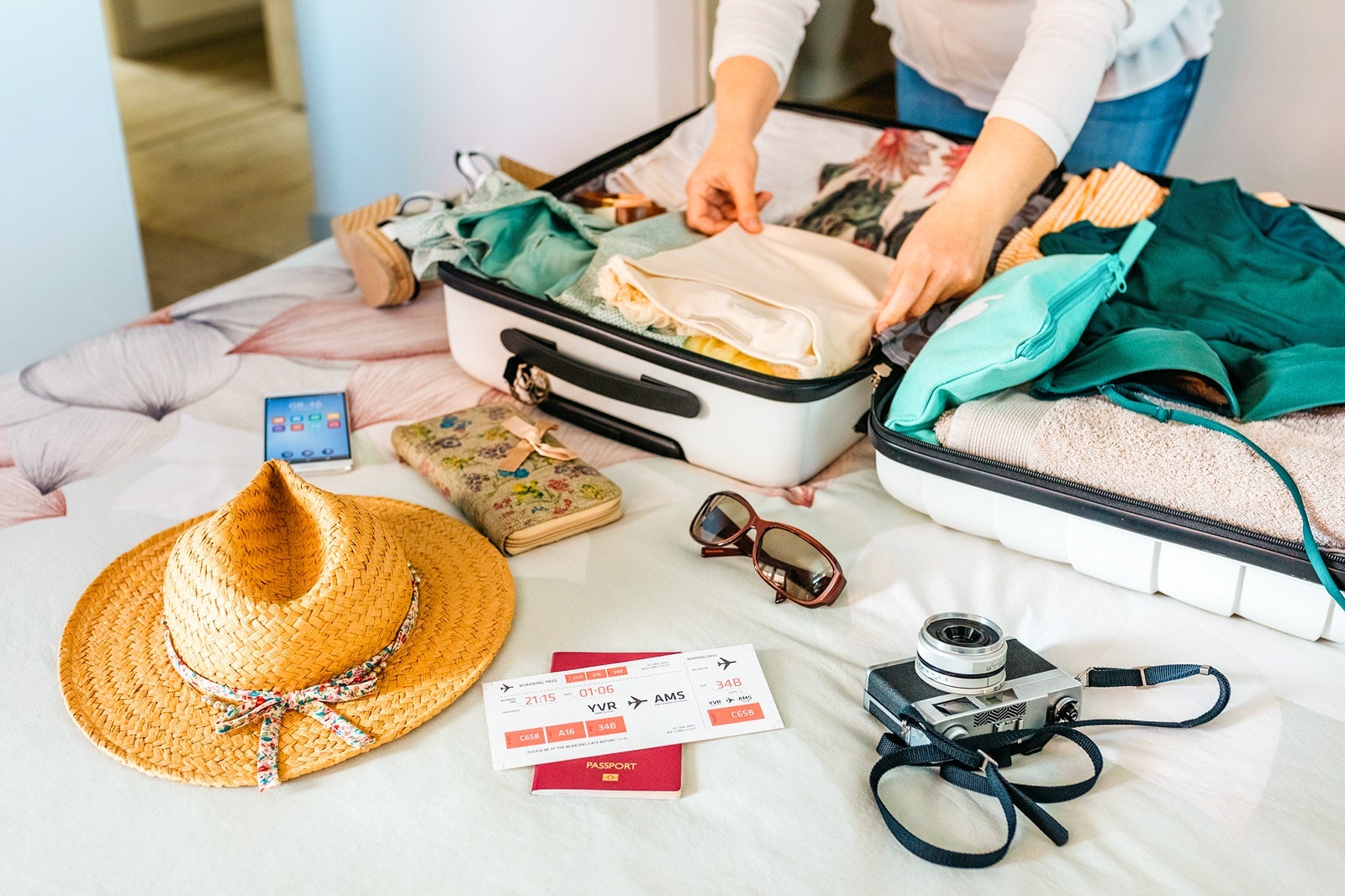 Unrecognizable woman preparing suitcase for summer holidays