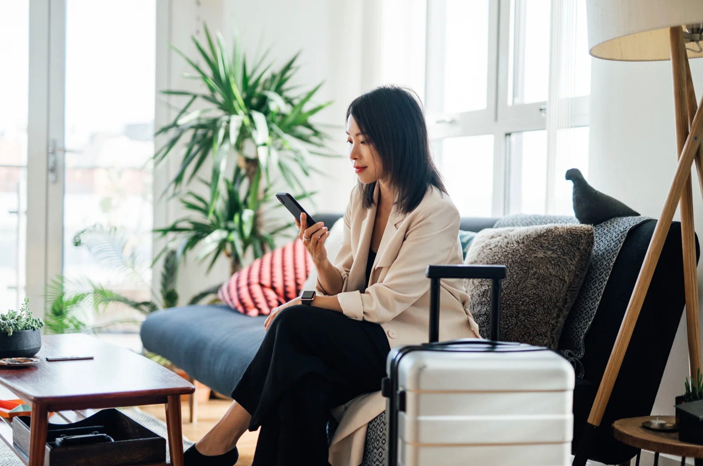 Smiling businesswoman using mobile phone at home