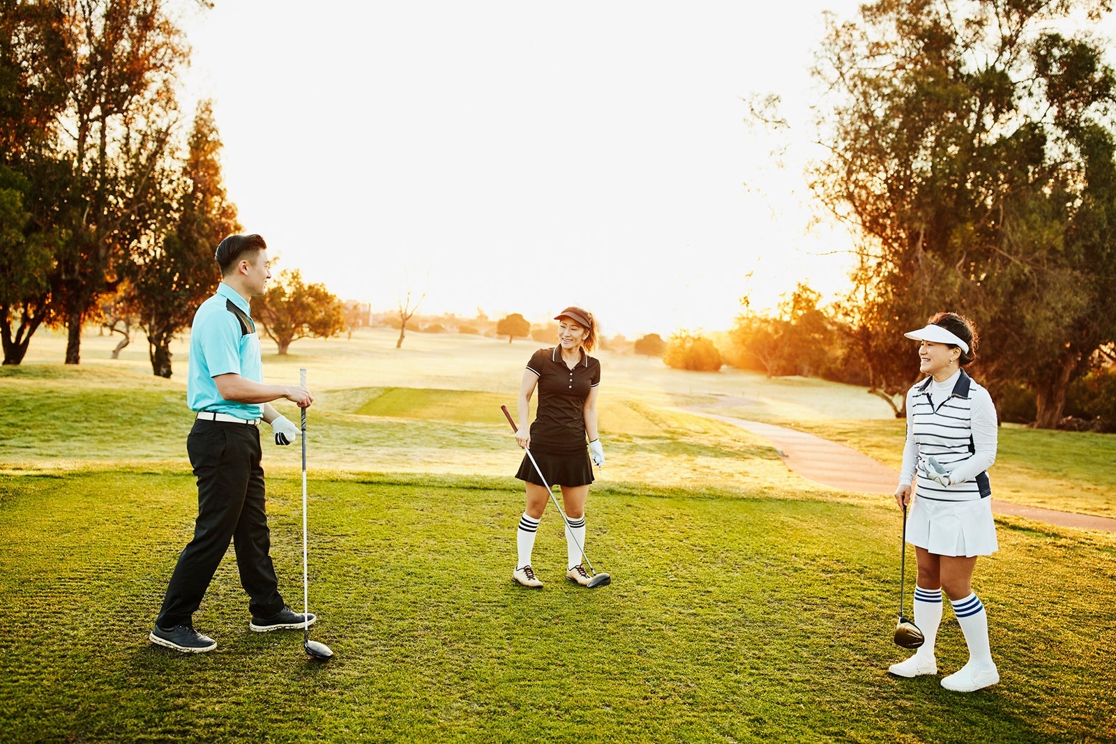 Laughing family playing round of golf together