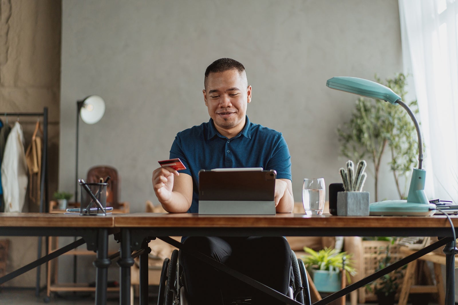 Man shopping online with credit card at desk