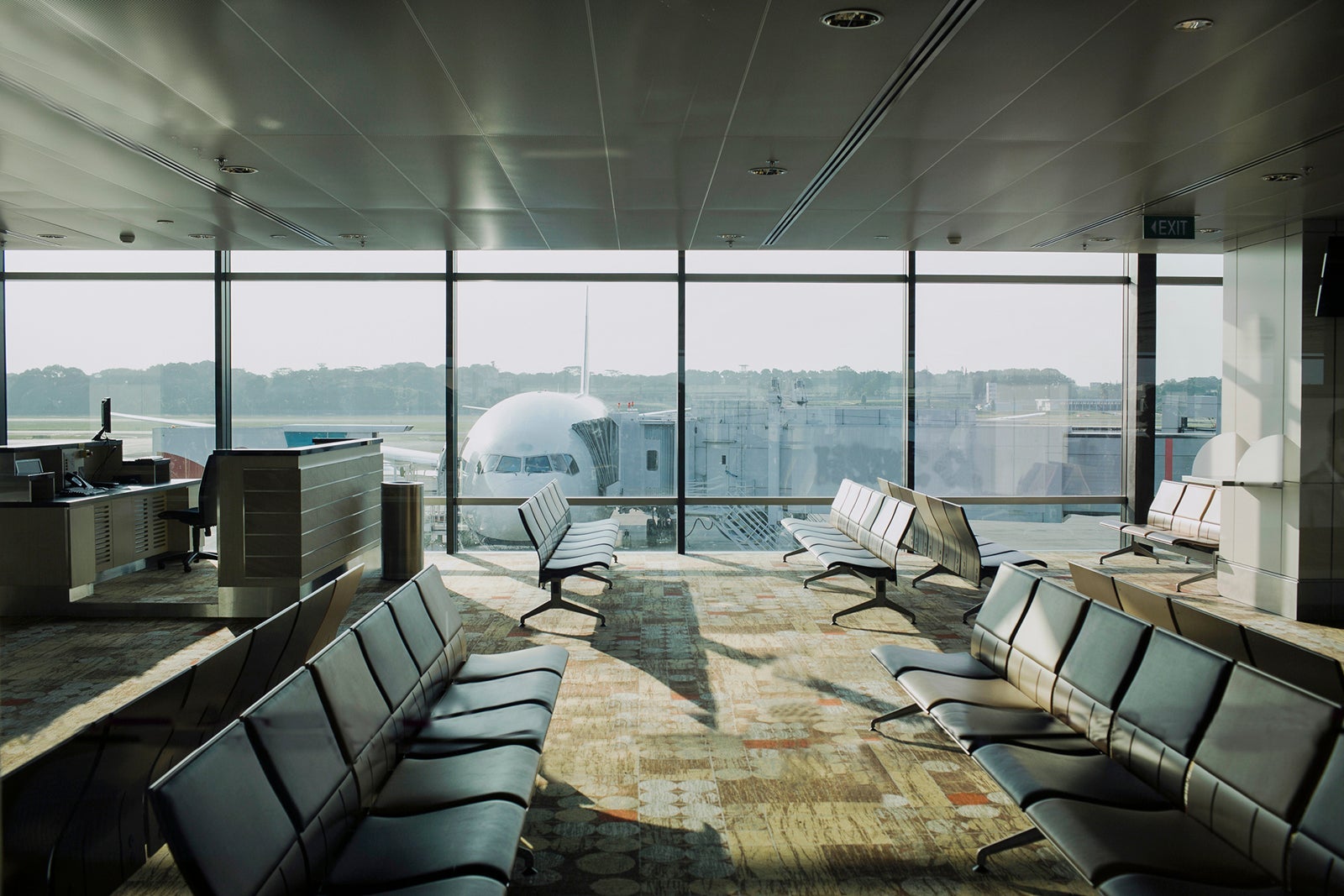 Empty airport lounge with plane outside.