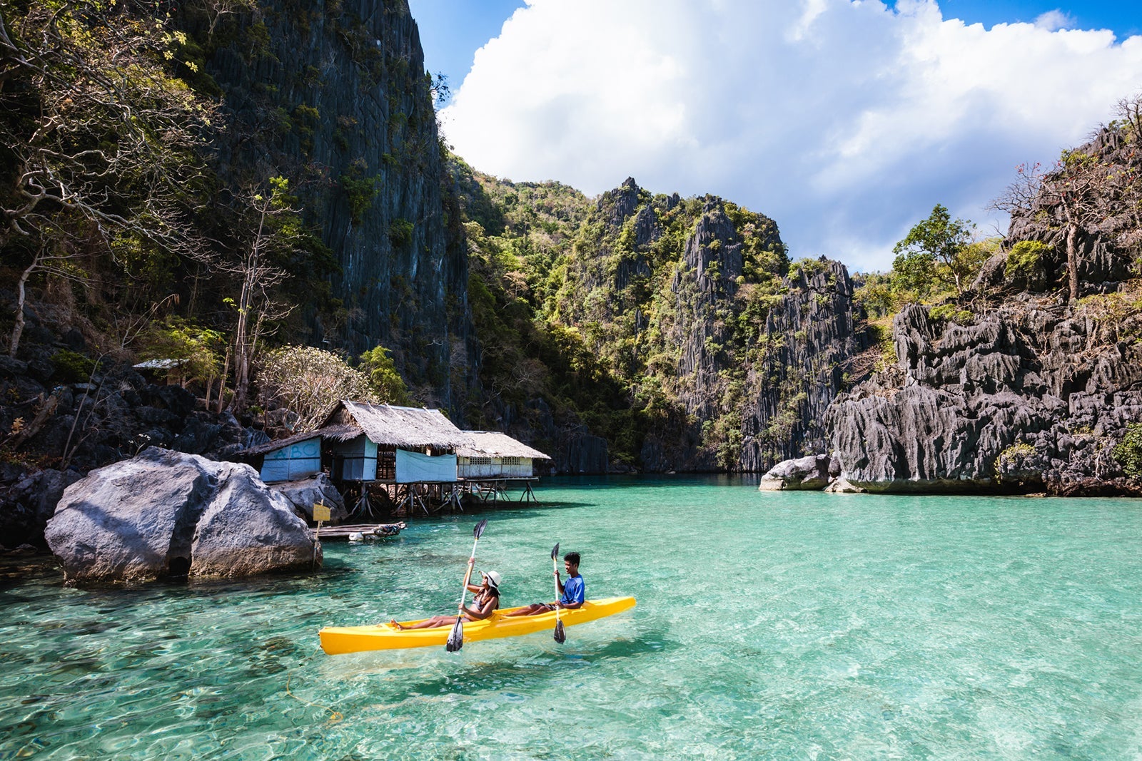 Asian couple kayaking in a lagoon, Coron, Palawan, Philippines