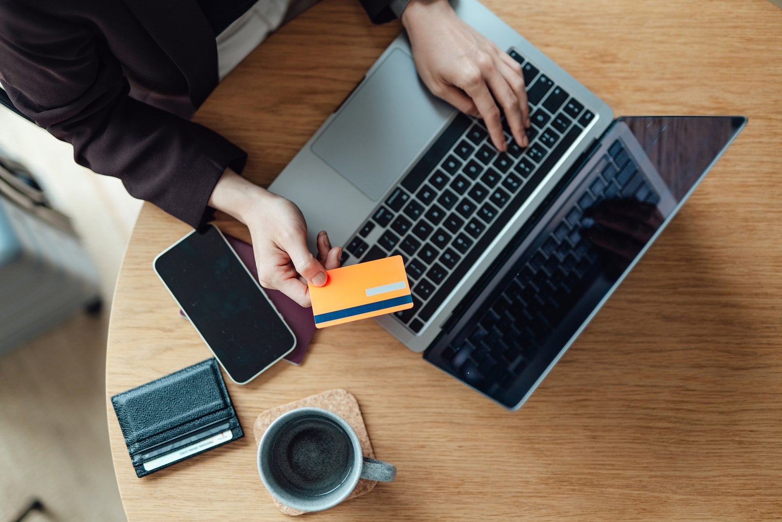 Elevated view of female hands making credit card payment via laptop while doing online shopping