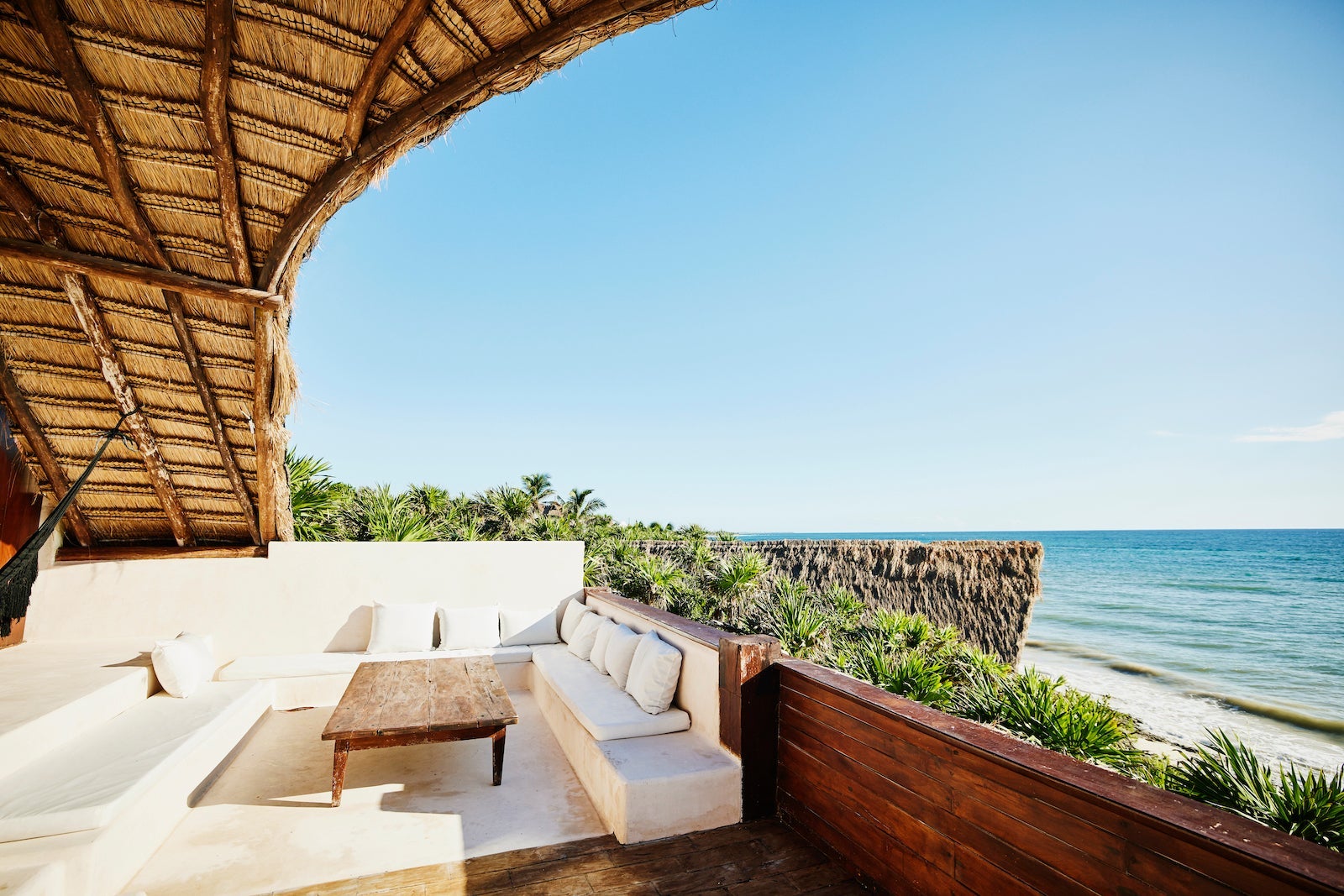 Wide shot of sitting area on deck of luxury suite at tropical resort