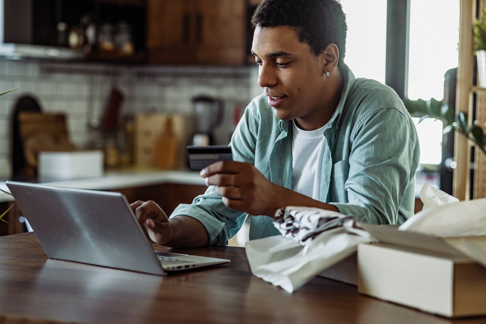 Young man enjoying in online shopping at home