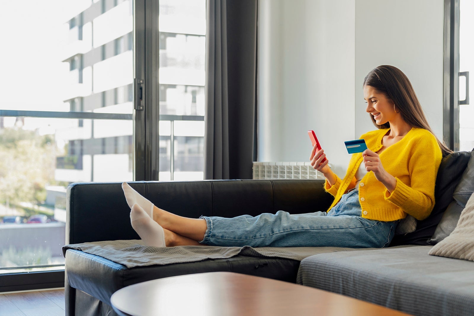 Smiling woman with credit card doing online shopping at home