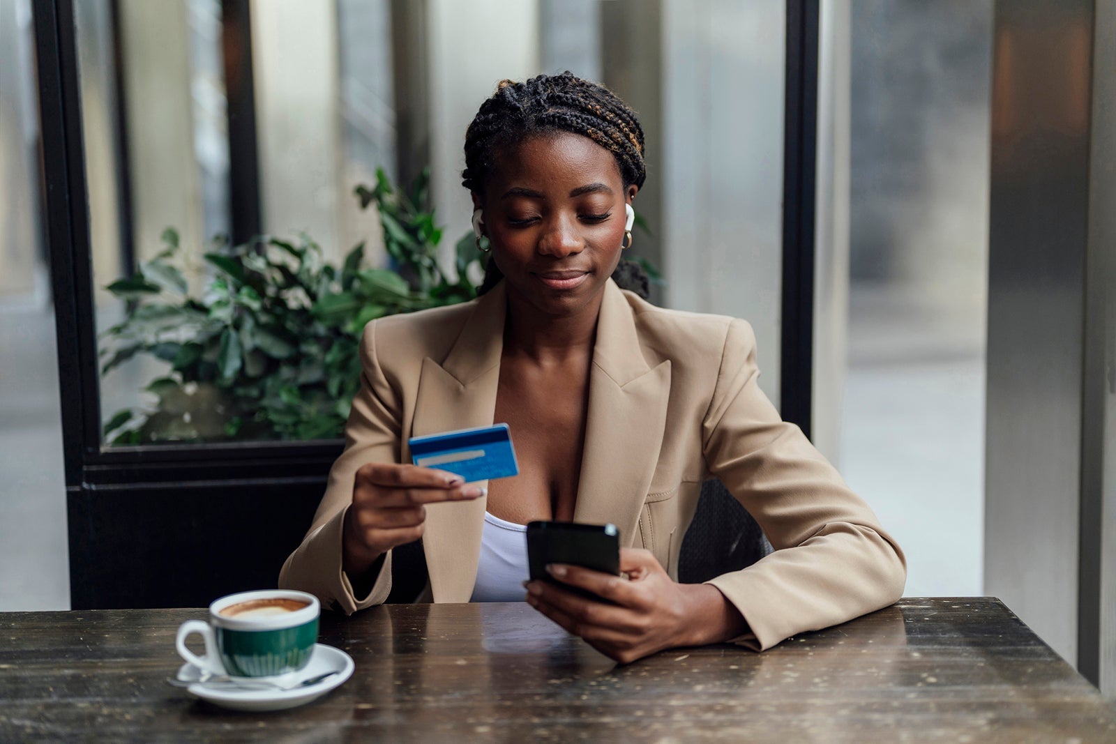 Businesswoman with credit card and smart phone sitting at cafe