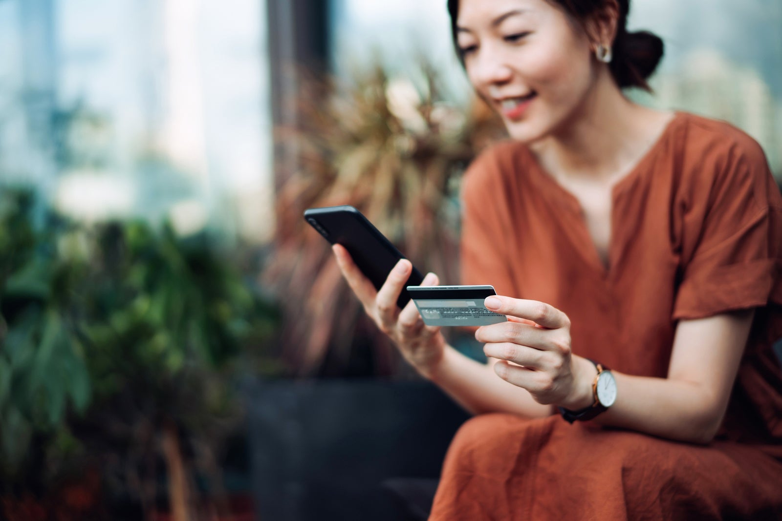 Woman relaxing on deck chair with smartphone and card