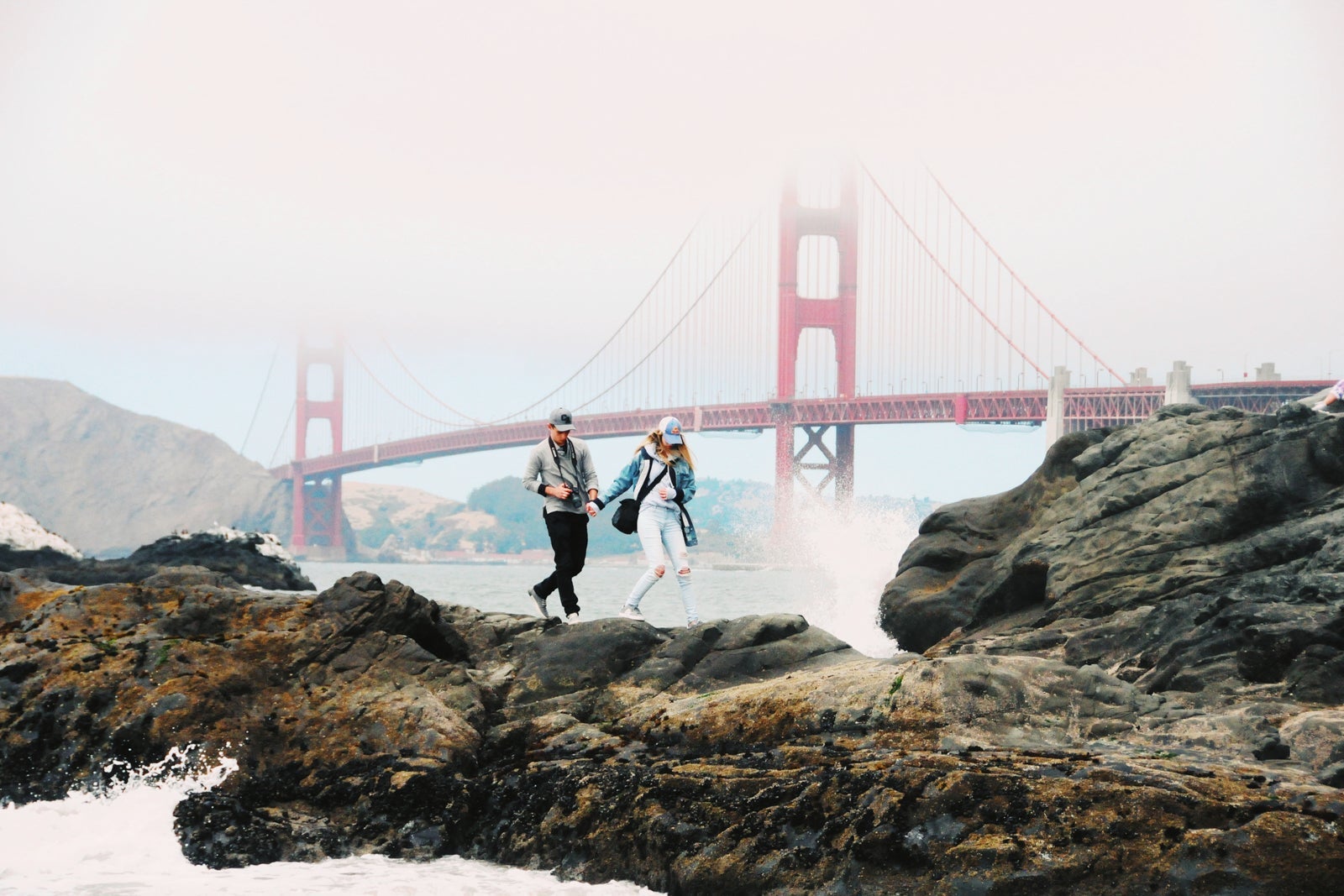 Full Length Of Couple Standing Against Suspension Bridge